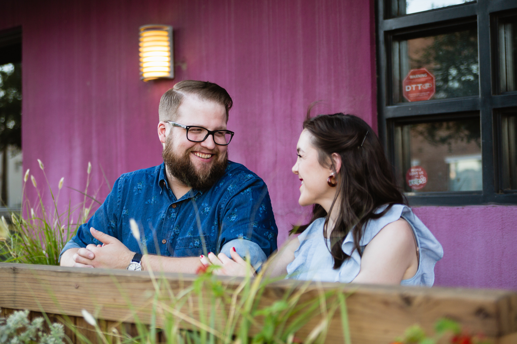 Couple of image laughing together at a cafe during their engagement session by Arizona engagement photographer PMA Photography. 