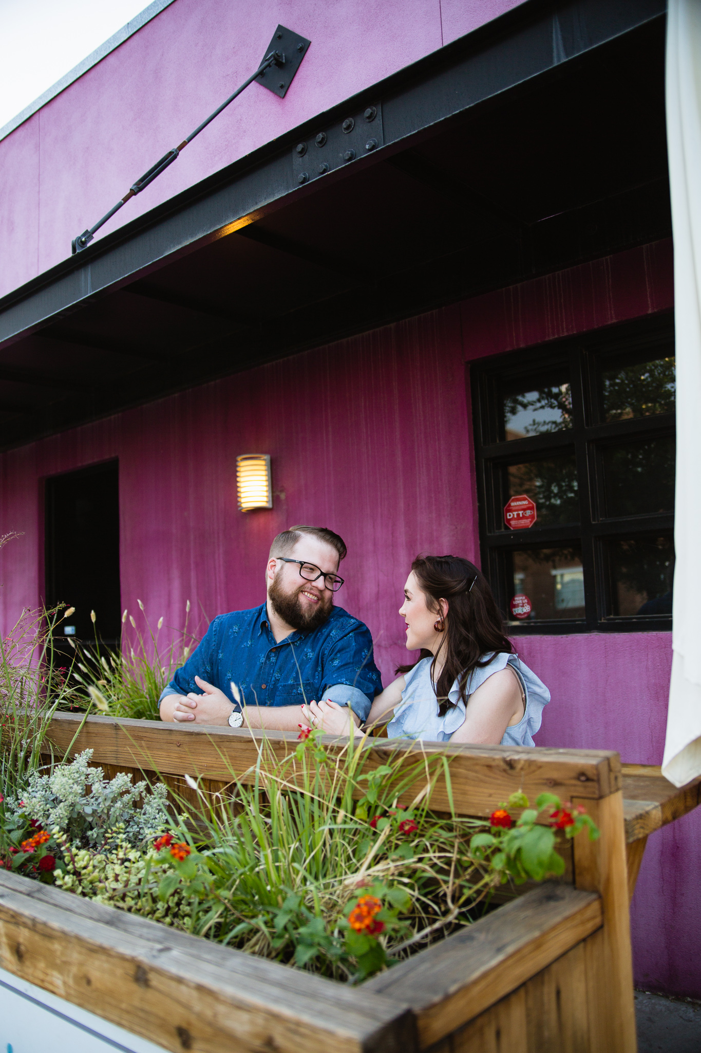 Couple of image laughing together at a cafe during their engagement session by Arizona engagement photographer PMA Photography. 