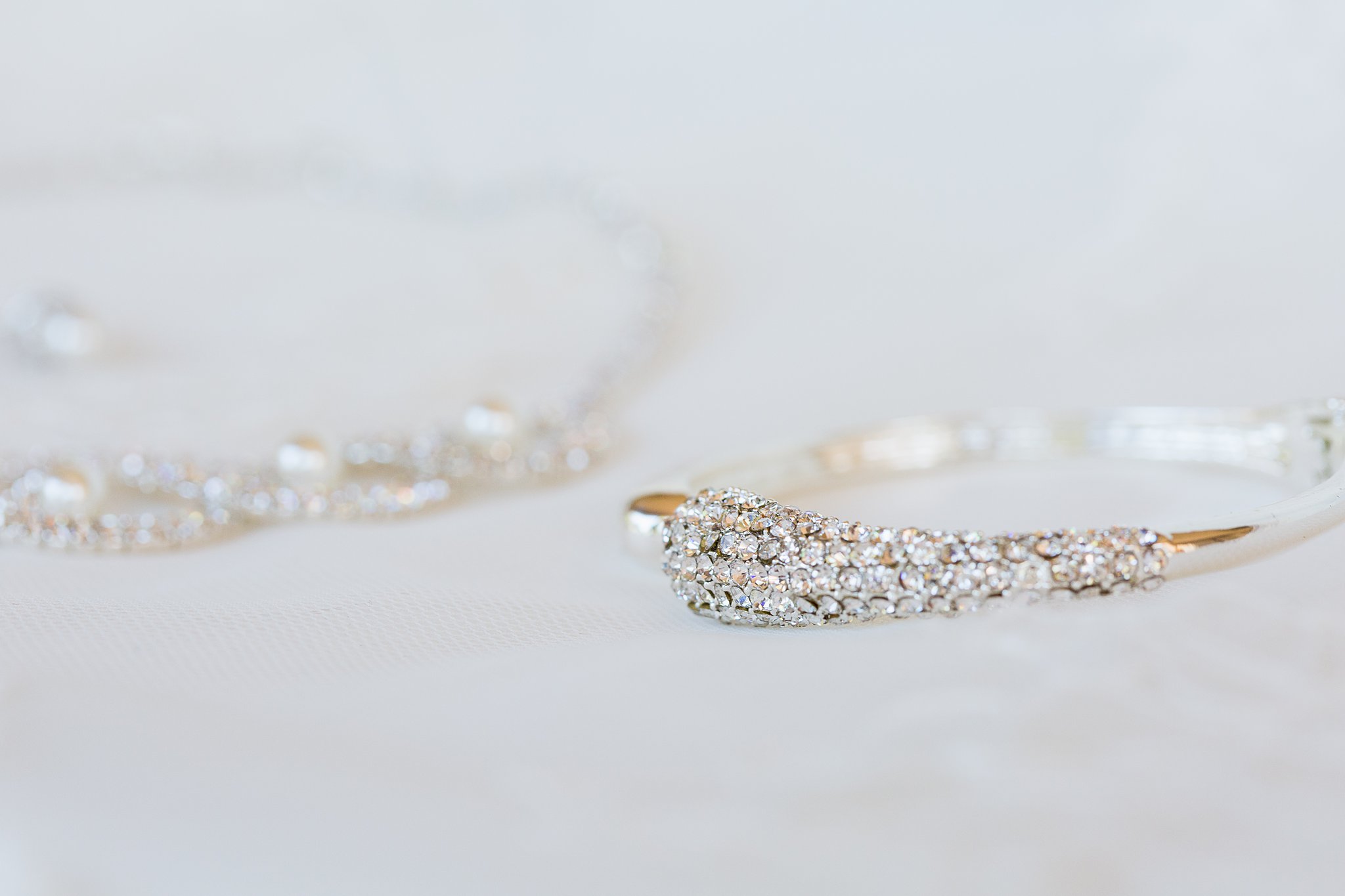 Brides's wedding day details of a bracelet and necklace by PMA Photography.