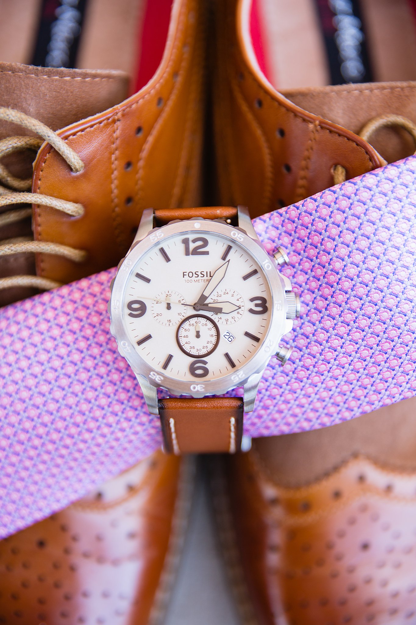 Groom's wedding day details of tan watch and pink tie by PMA Photography.