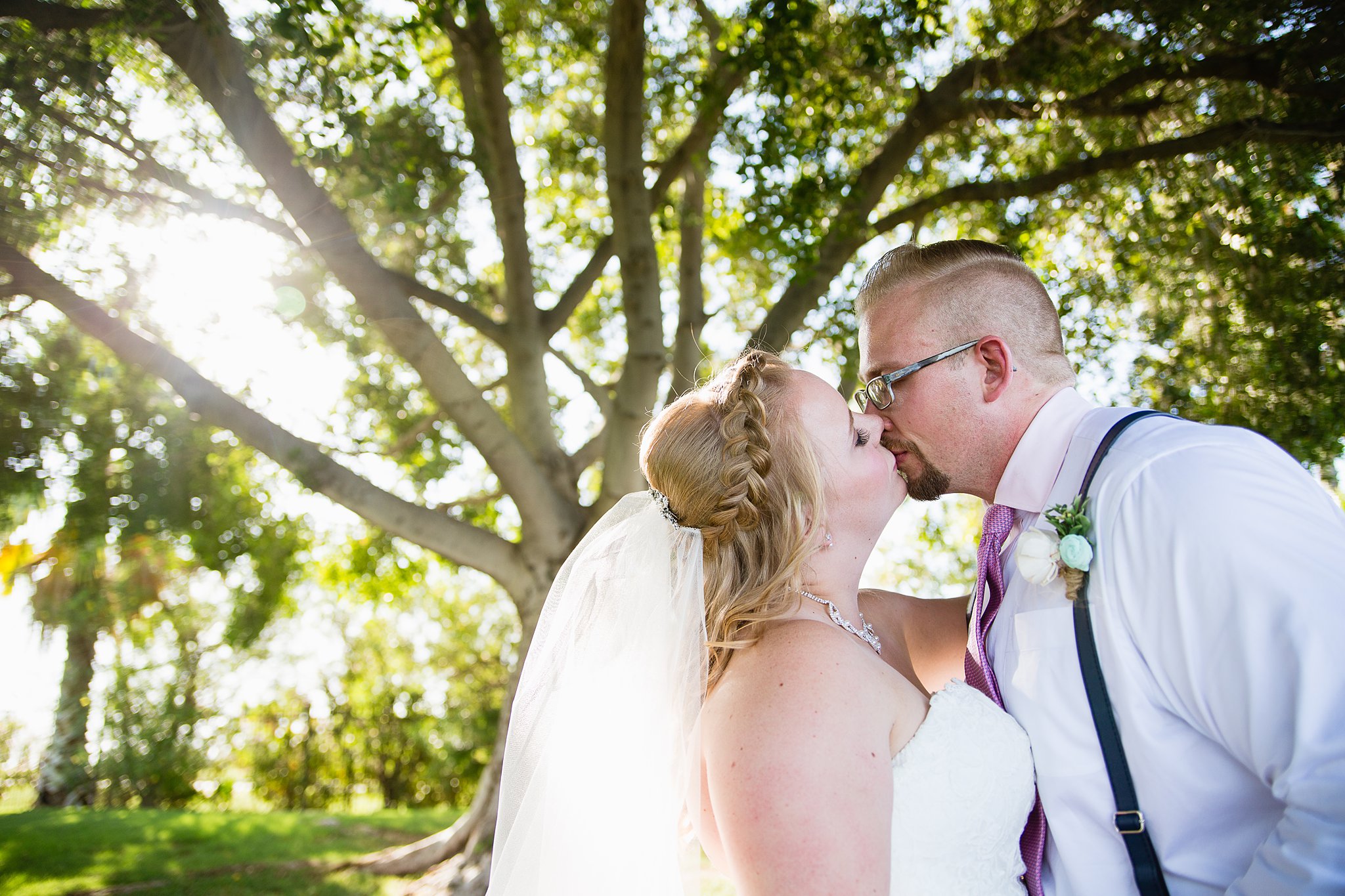 Bride and groom share a kiss during their Val Vista Lakes wedding by Gilbert wedding photographer PMA Photography.