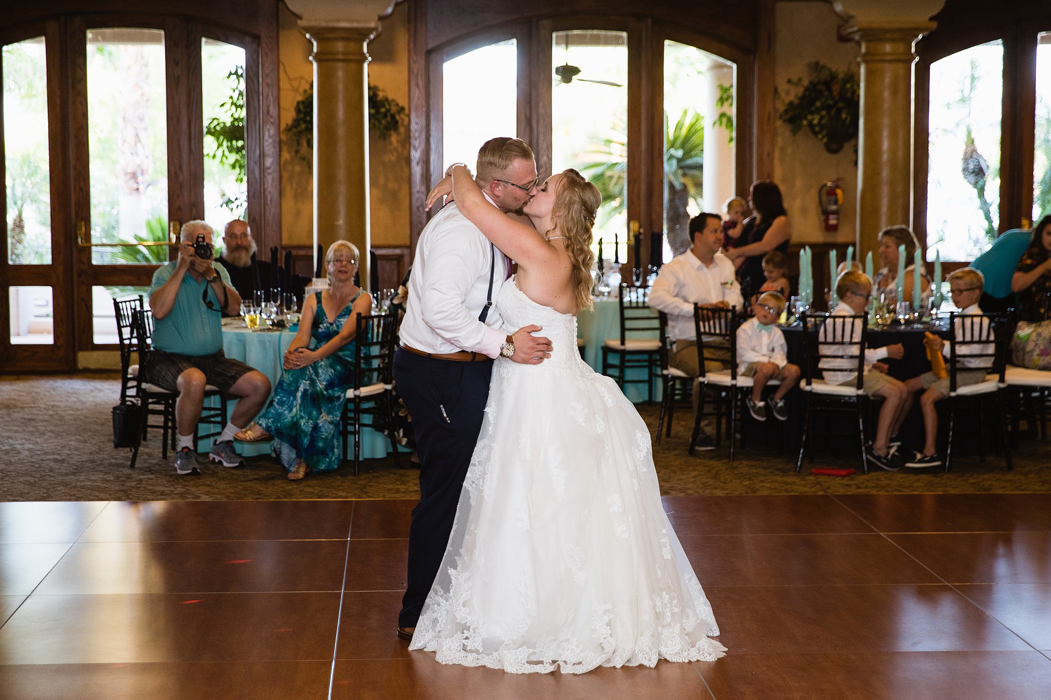 Bride and groom sharing first dance at their Val Vista Lakes wedding reception by Arizona wedding photographer PMA Photography.