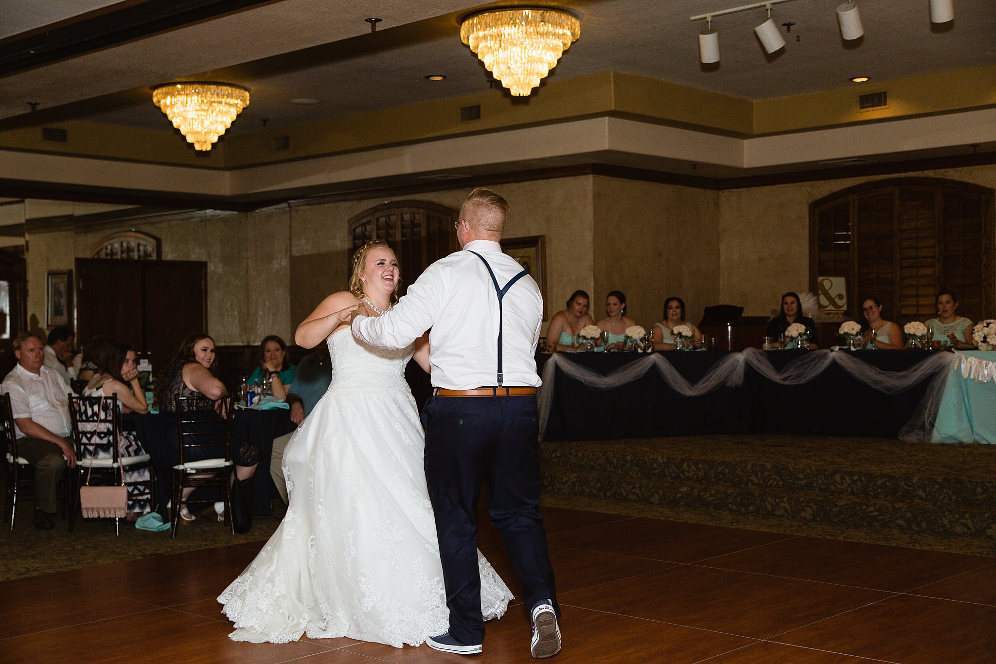 Bride and groom sharing first dance at their Val Vista Lakes wedding reception by Arizona wedding photographer PMA Photography.