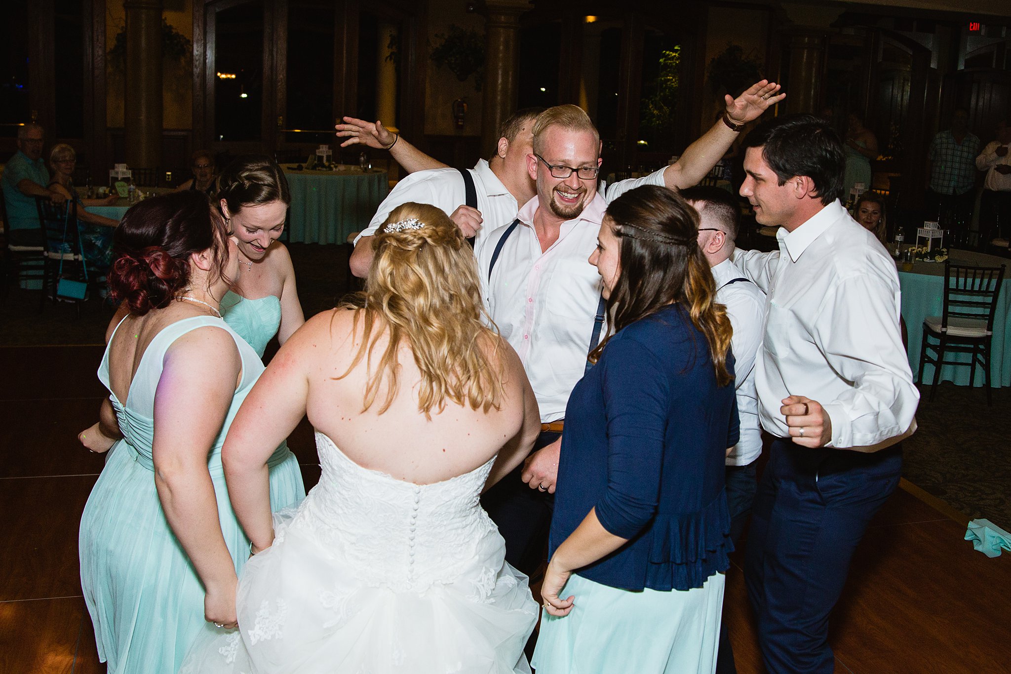 Bride and groom dancing with guests at their Val Vista Lakes wedding reception by Arizona wedding photographer PMA Photography