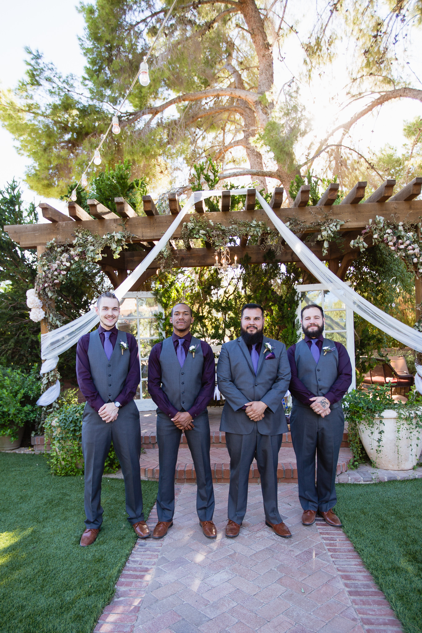 Groom with groomsmen in purple and grey suite at Schnepf Farms by Phoenix wedding photographer PMA Photography.