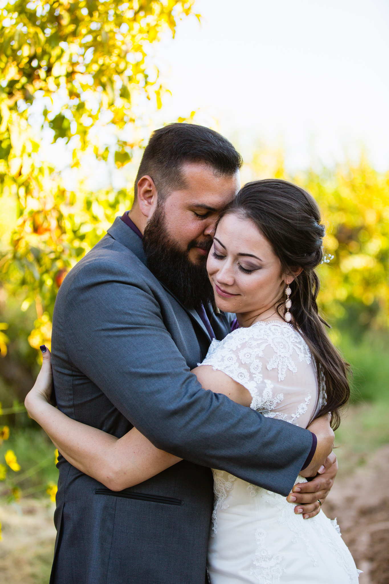 Bride and groom share an intimate moment in the Schnepf Farm's orchard after the ceremony by Phoenix wedding photographer PMA Photography.