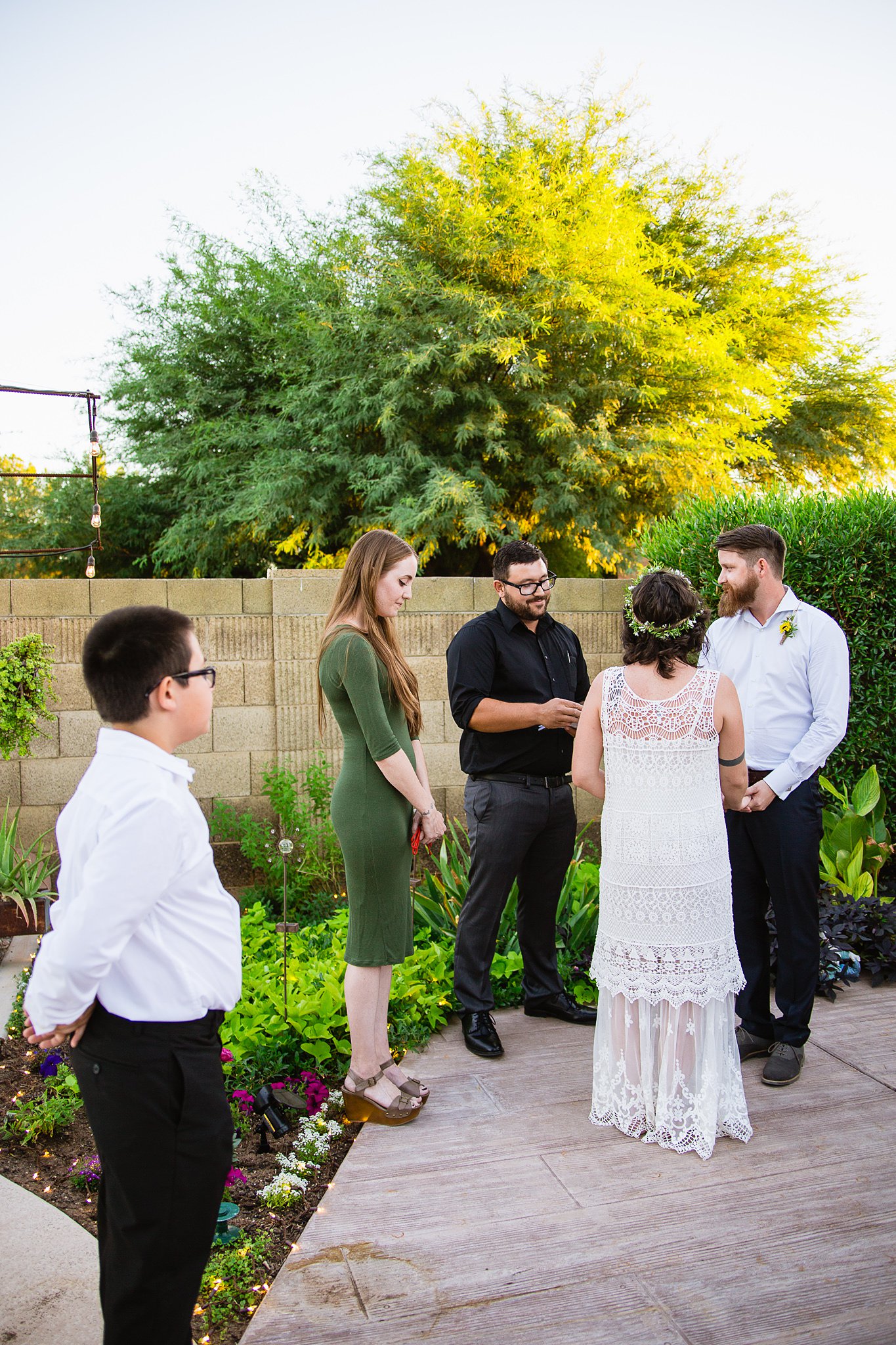 Bride's son watches the Arizona backyard garden wedding ceremony by Phoenix wedding photographer PMA Photography.