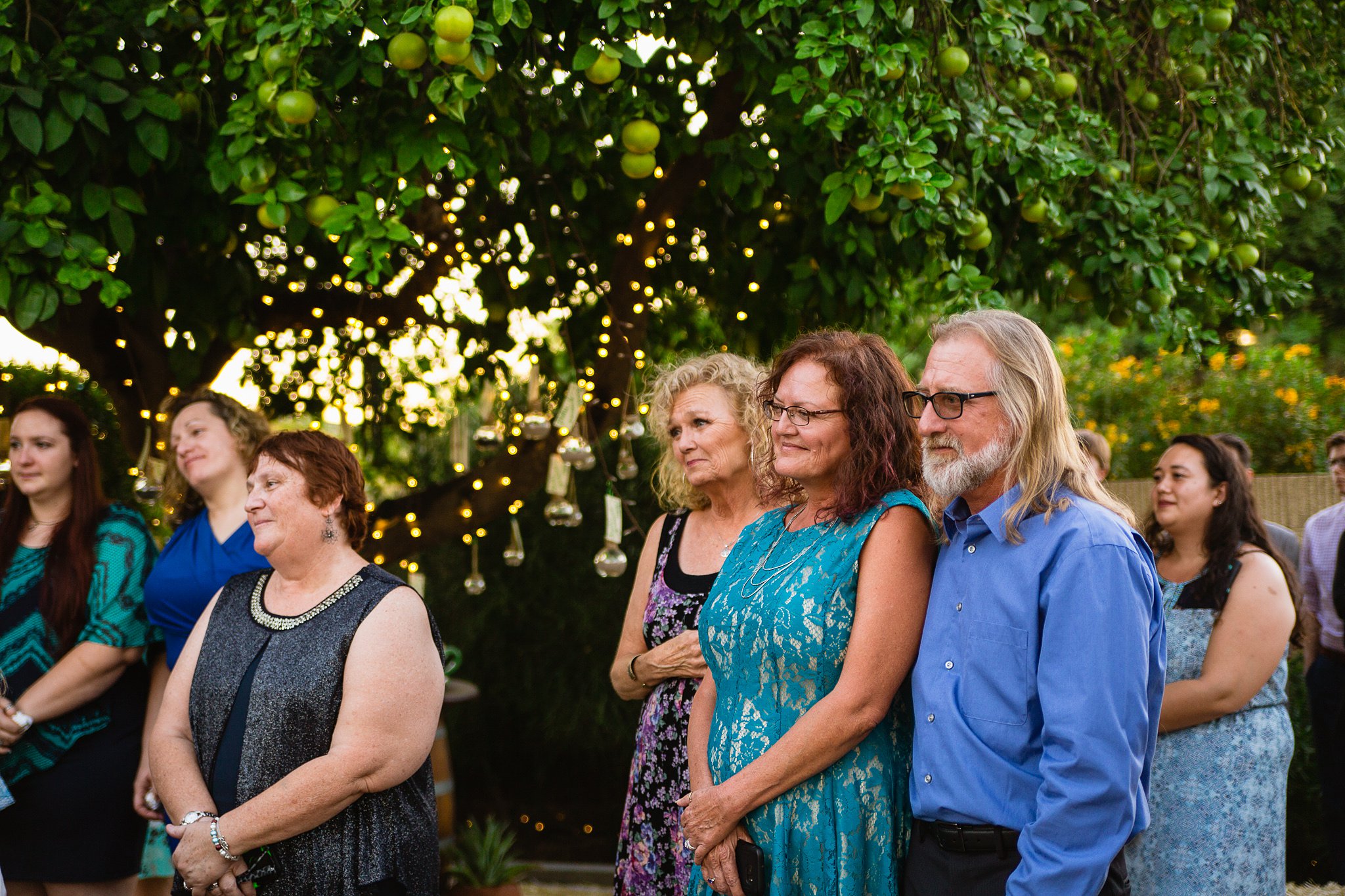 Bride and groom's parents watch as their children get married in an Arizona backyard garden wedding by PMA Photography.