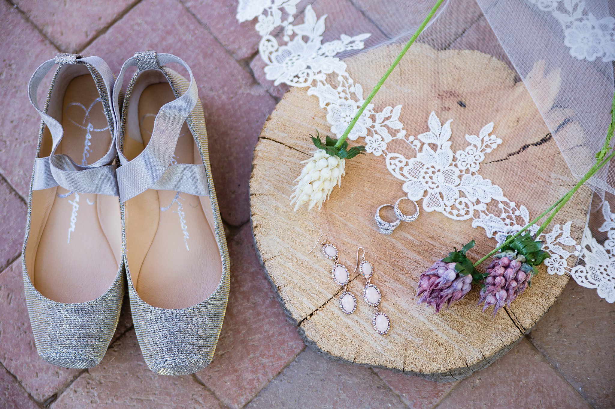 Bridal wedding details featuring silver flats and pink drop earrings by wedding photographers PMA Photography.