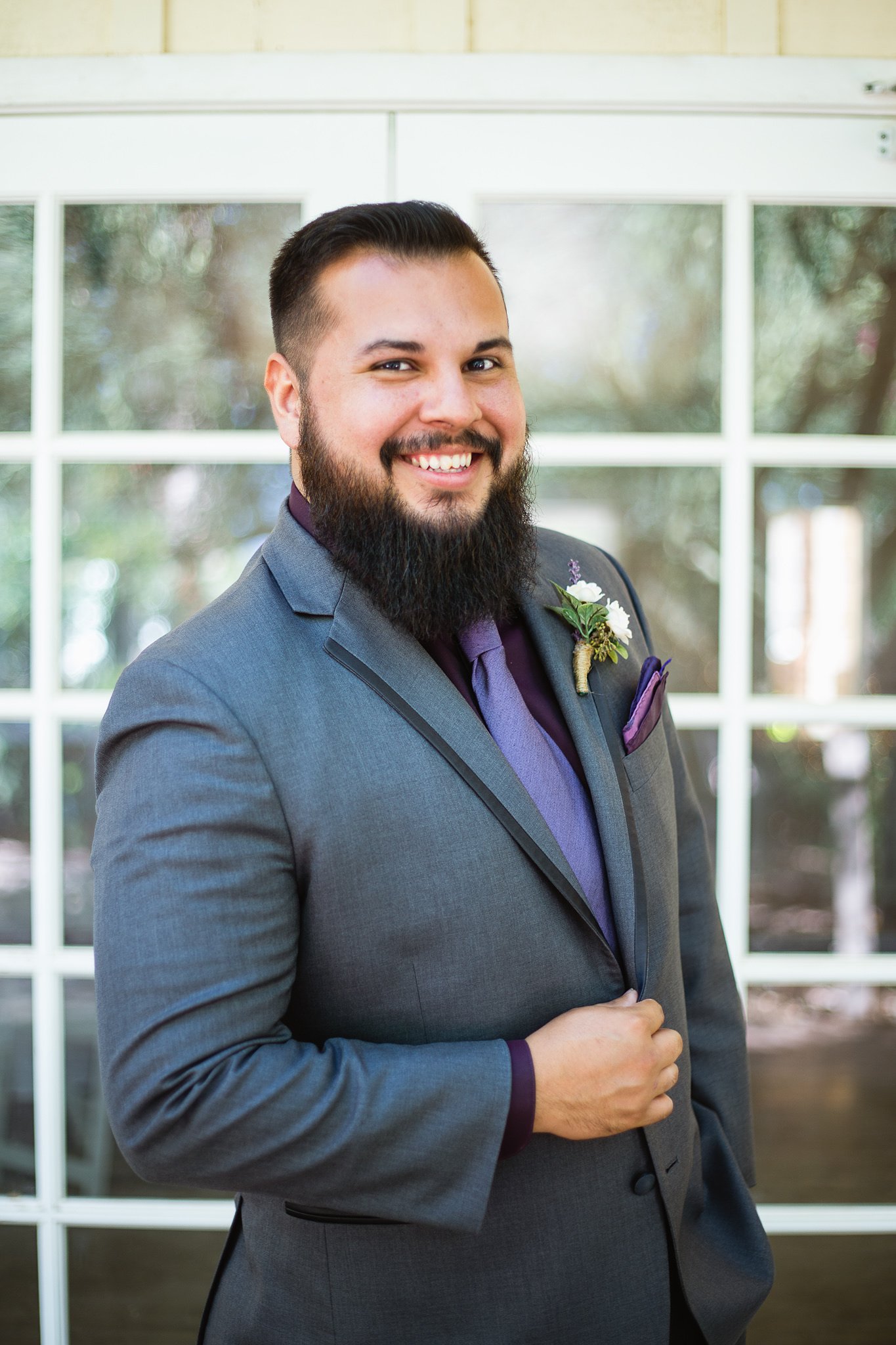 Portrait of a groom on his wedding day in a purple and grey suit by Arizona wedding photographer PMA Photography.