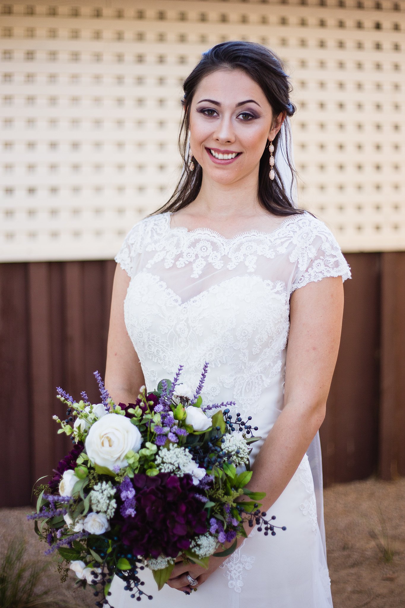 Bride holding purple and white bridal bouquet by Phoenix wedding photographer PMA Photography.