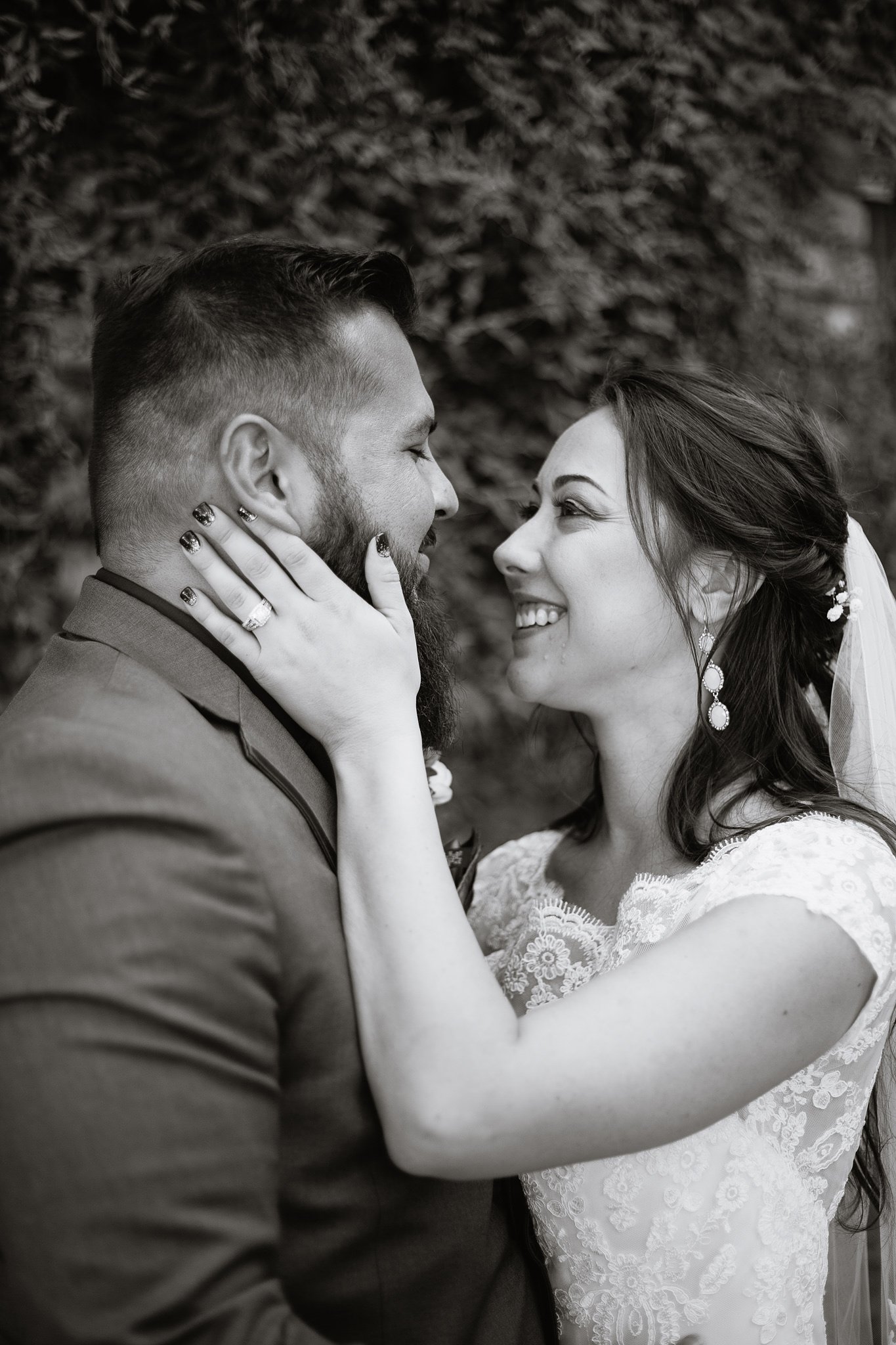 Black and white photo of bride and groom sharing a happy intimate moment at their Schnepf Farm's wedding by Queen Creek wedding photographer PMA Photography.