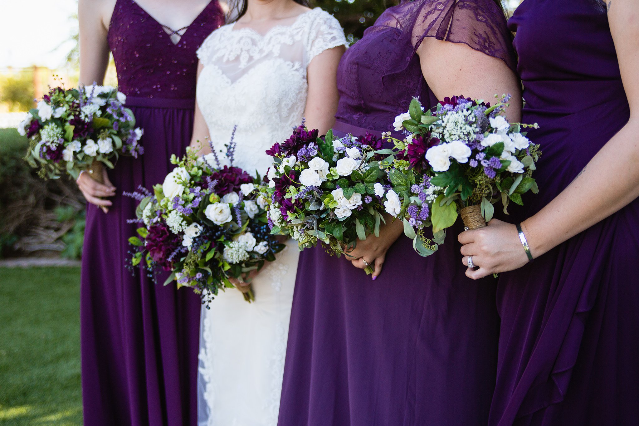 Purple, white, and green silk bridal party bouquets by wedding photographer PMA Photography.