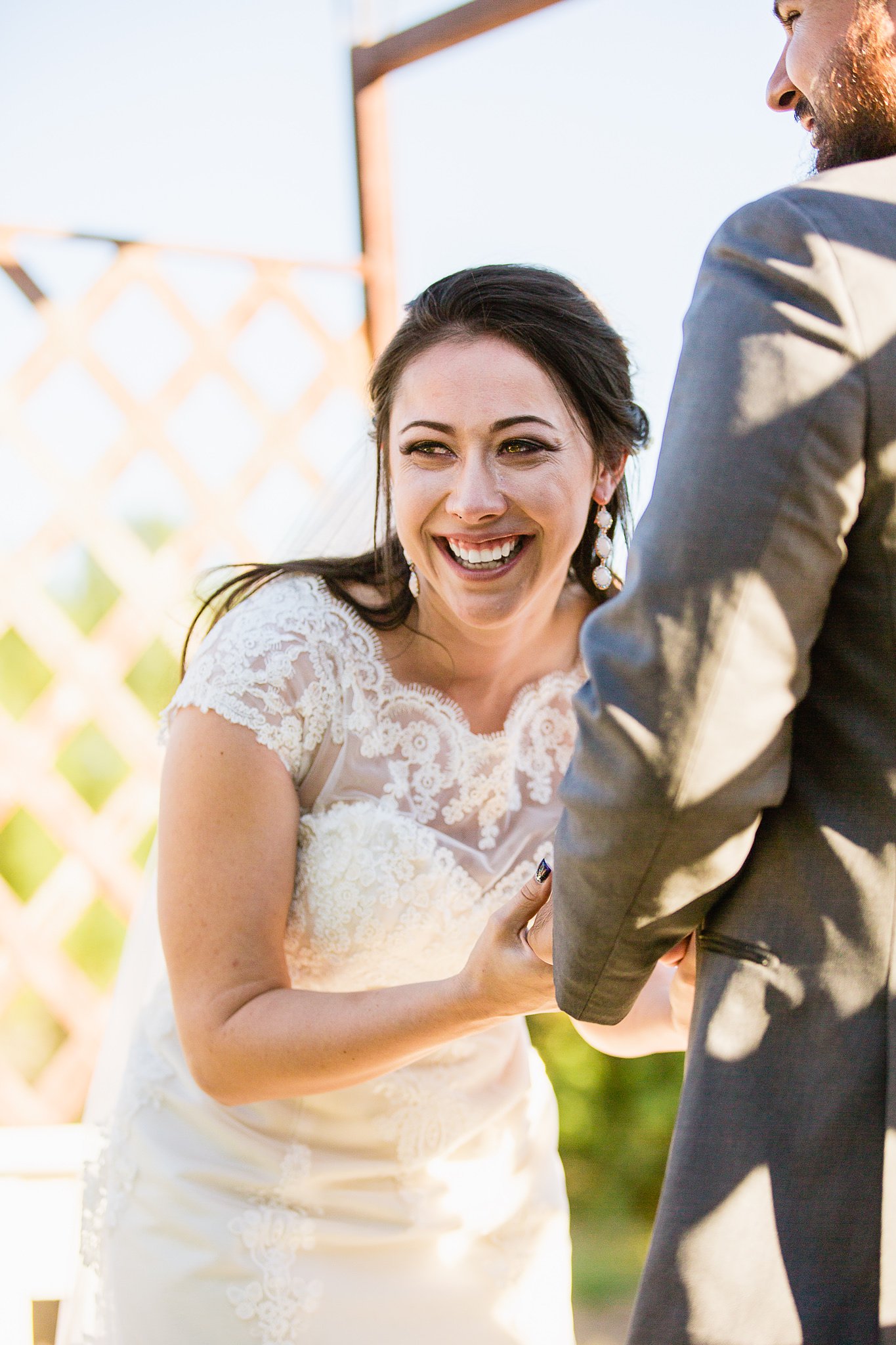 Bride laughing with tears in her eyes during her wedding ceremony at the Schnepf Farm's Farmhouse by Arizona wedding photographer PMA Photography.
