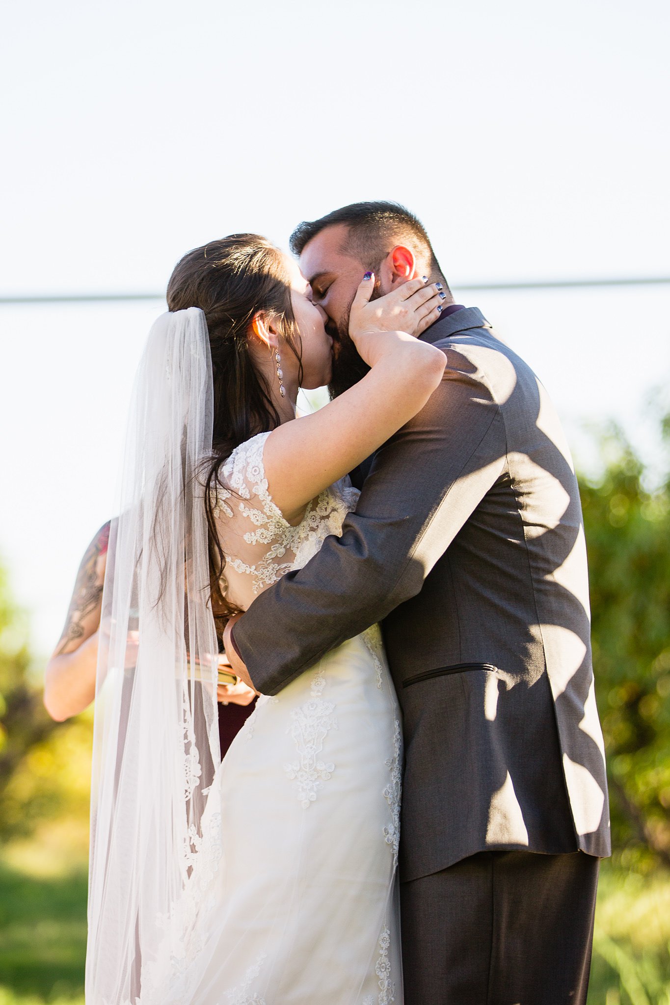 Bride and groom's first kiss at their Wedding ceremony at the Schnepf Farm's Farmhouse by Arizona wedding photographer PMA Photography.