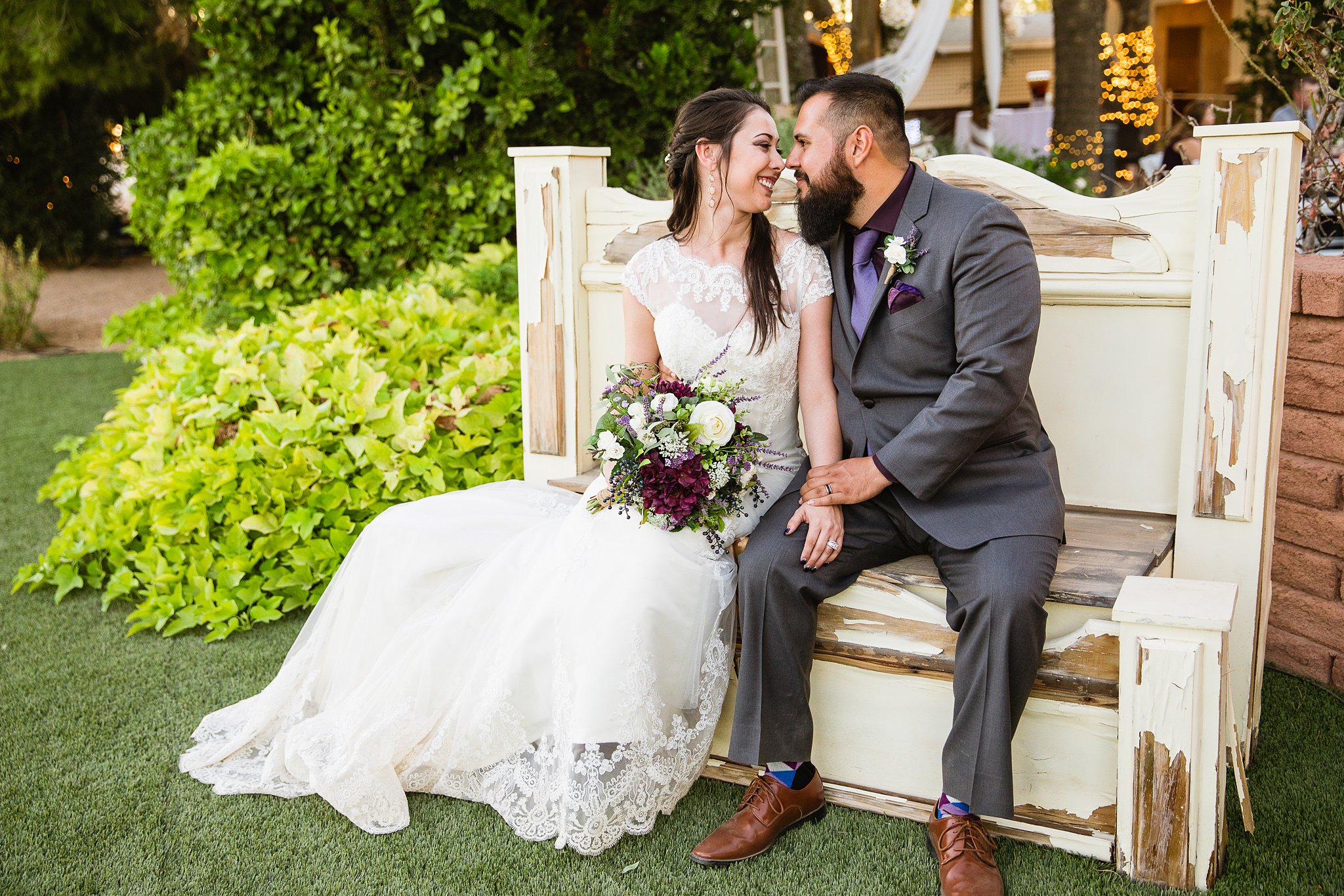 Bride and groom sitting together on a rustic bench at the Schnepf Farms Farmhouse by Arizona wedding photographer PMA Photography.