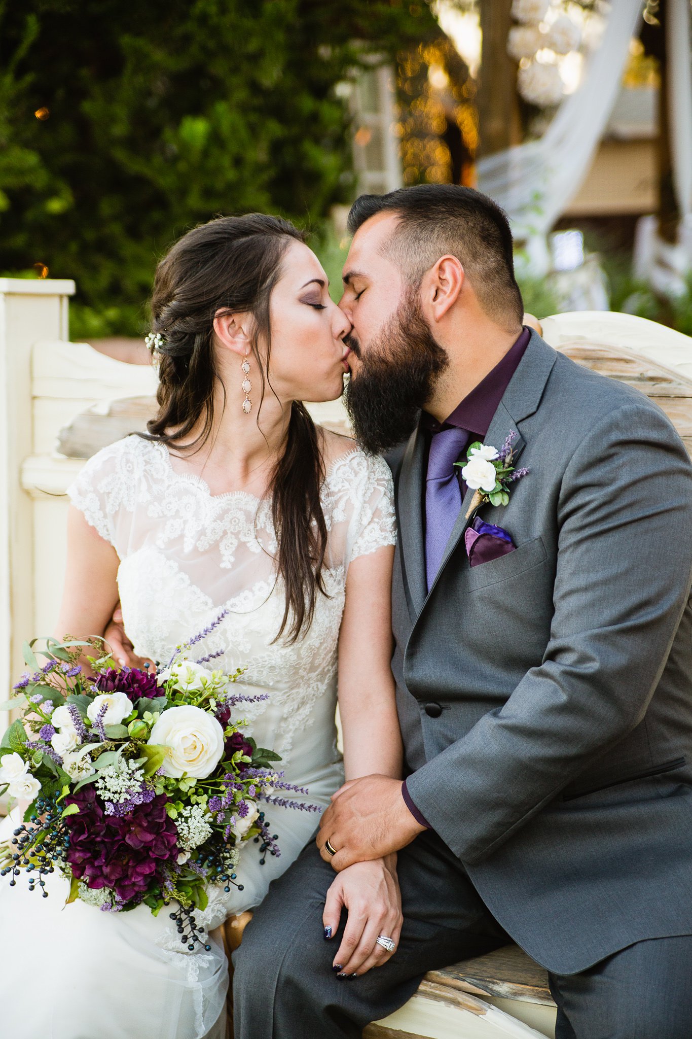  Bride and groom share a kiss on a rustic bench at the Schnepf Farms Farmhouse by Arizona wedding photographer PMA Photography.