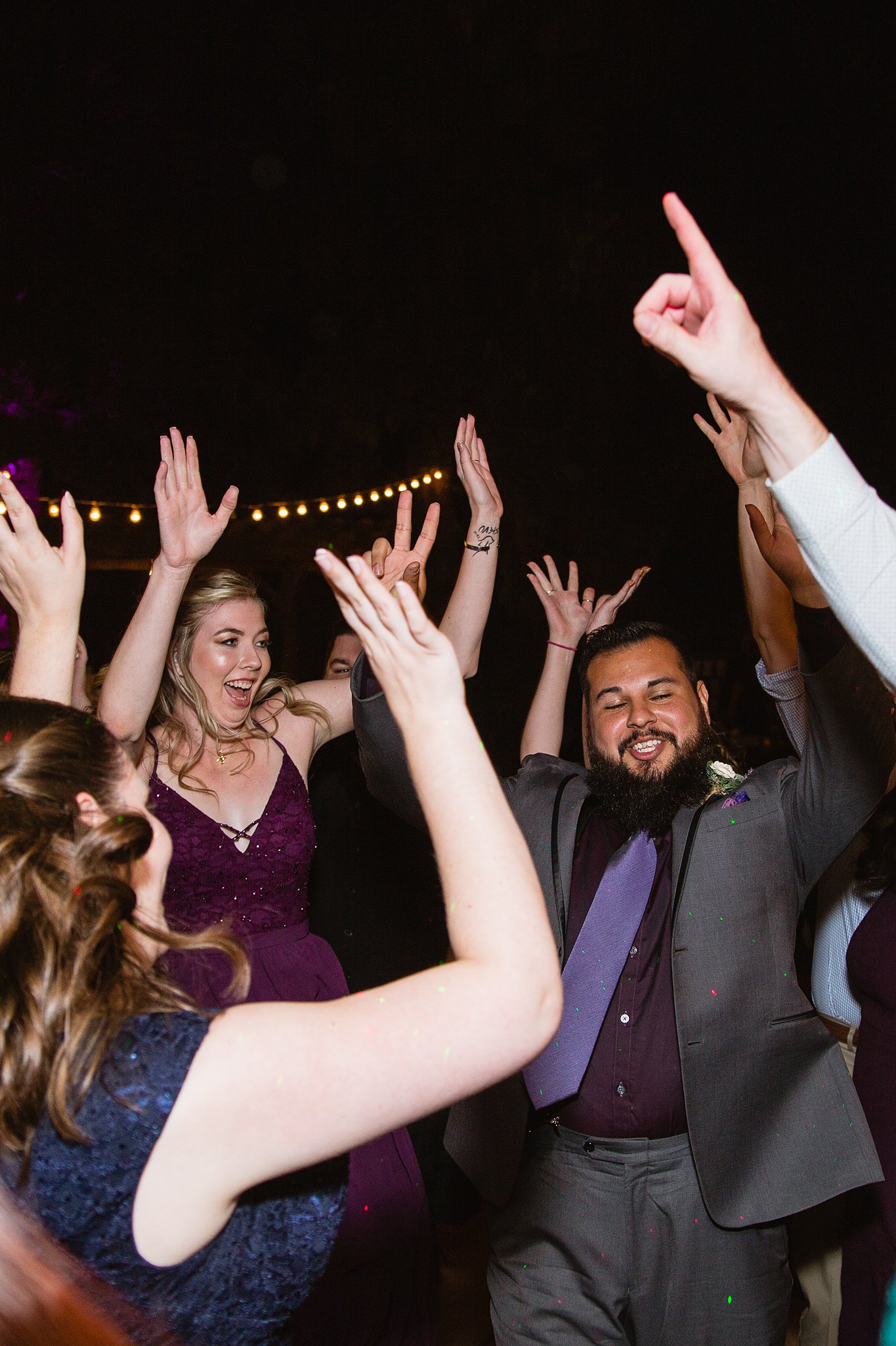 Groom having fun dancing with guests at his wedding reception by Arizona wedding photographer PMA Photography.