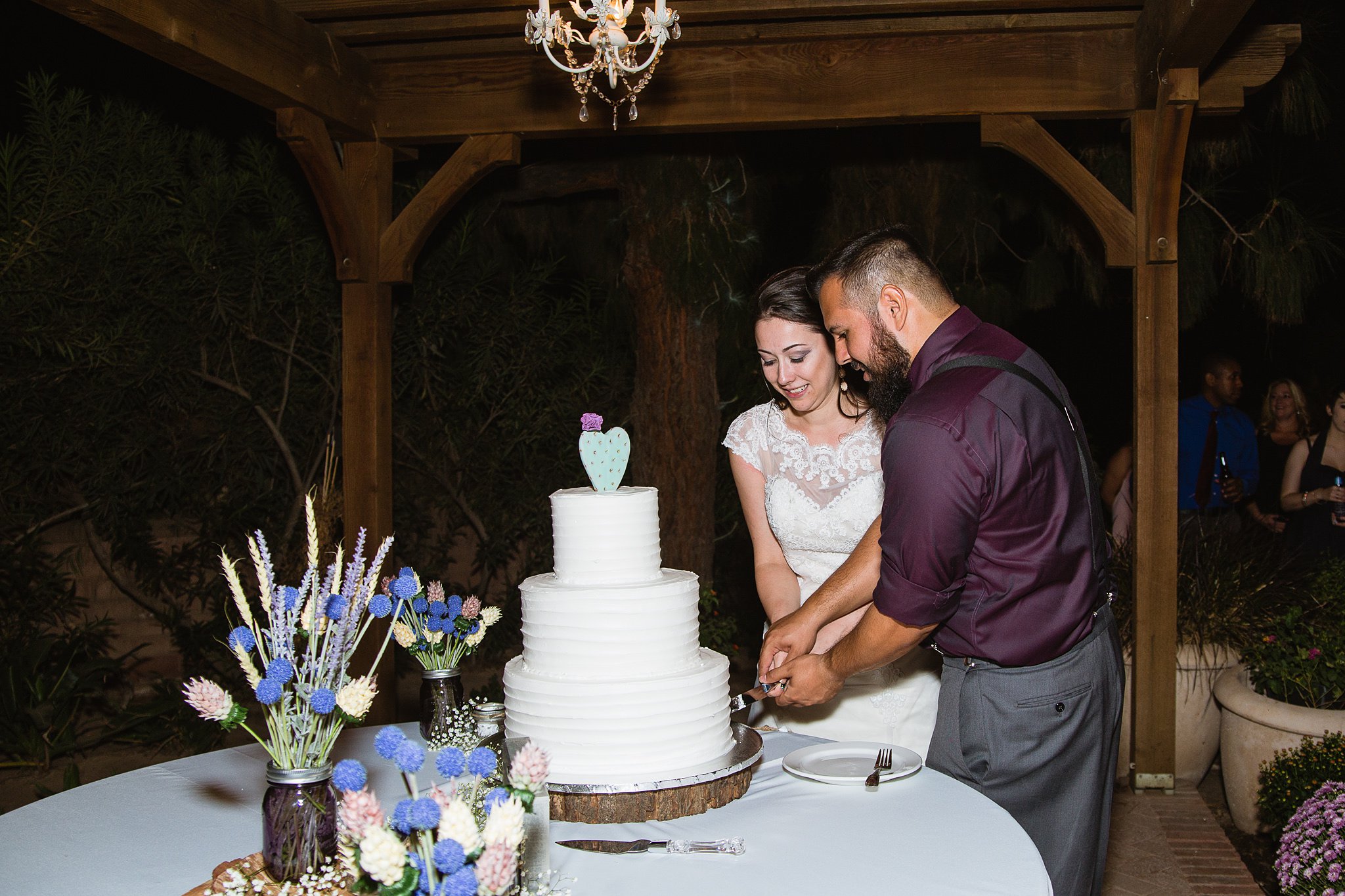 Bride and groom cutting the cake at their rustic chic wedding reception at Schnepf Farms Farmhouse by Arizona wedding photographer PMA Photography.