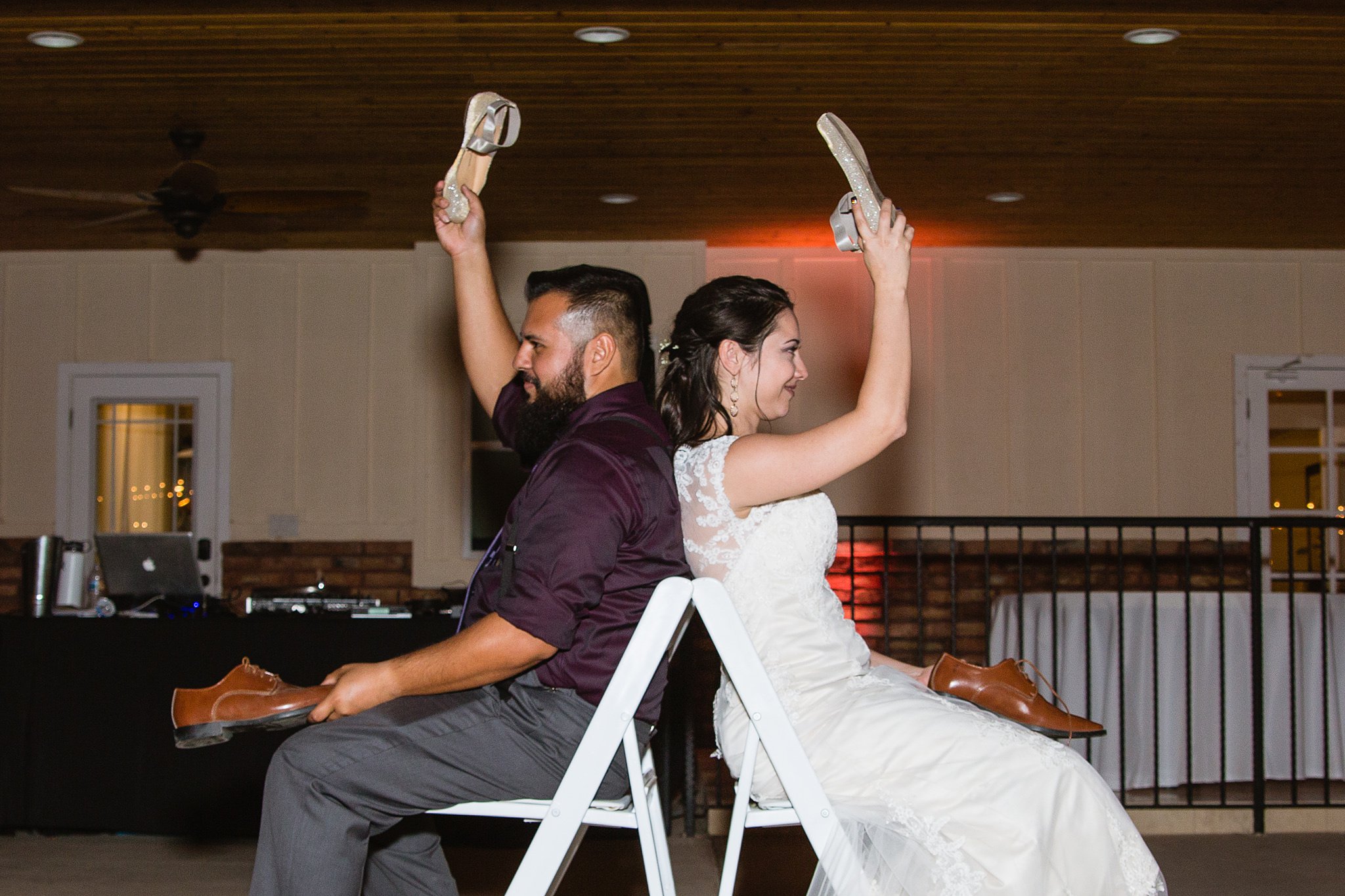 Bride and groom playing the newlywed shoe game by Phoenix wedding photographer PMA Photography.