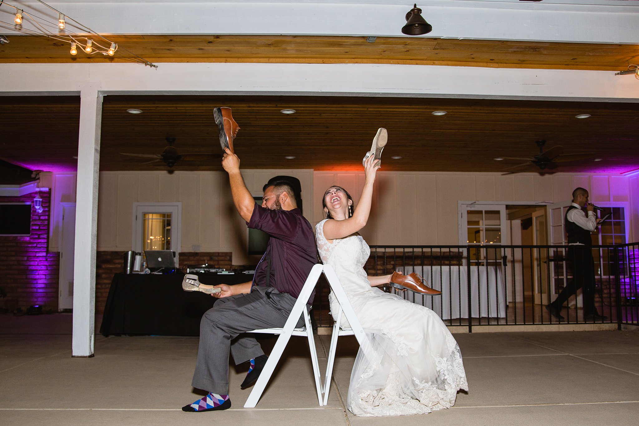 Bride and groom playing the newlywed shoe game by Phoenix wedding photographer PMA Photography.