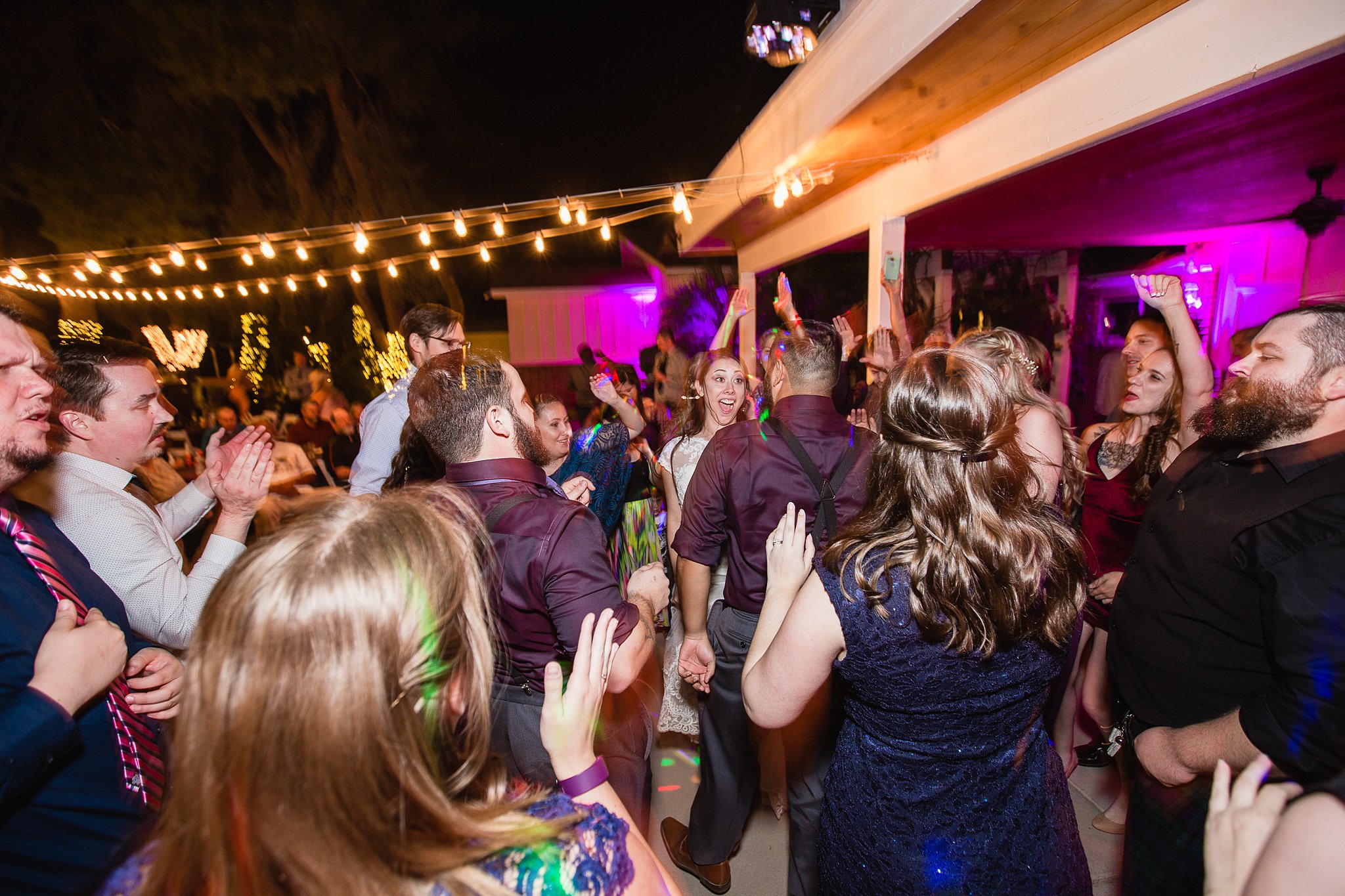 Bride and groom having a blast dancing with guests at their wedding reception by Arizona wedding photographer PMA Photography.