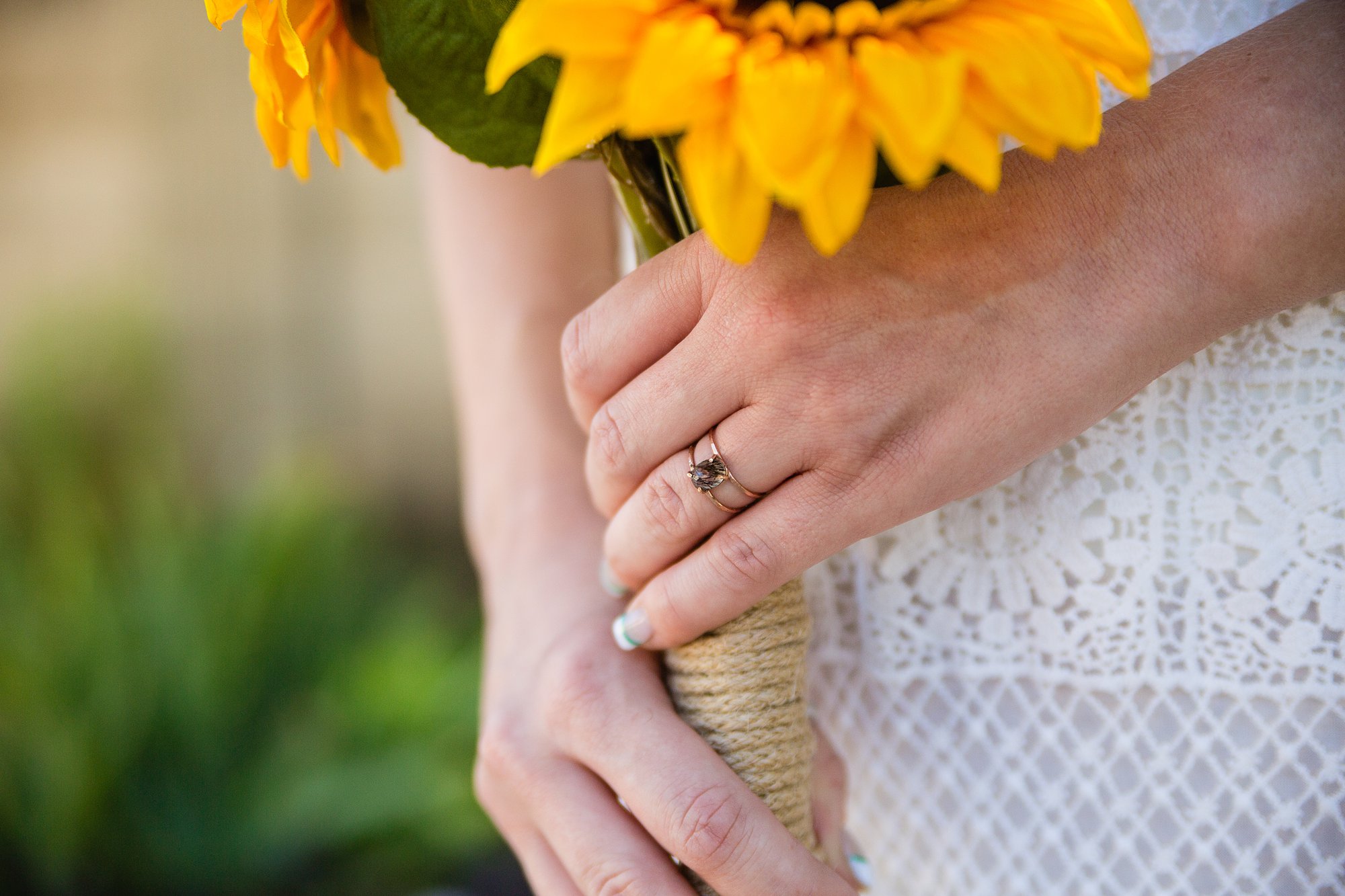 Close up image of a bride's unique engagement ring holding her bouquet by Arizona wedding photographers PMA Photography.