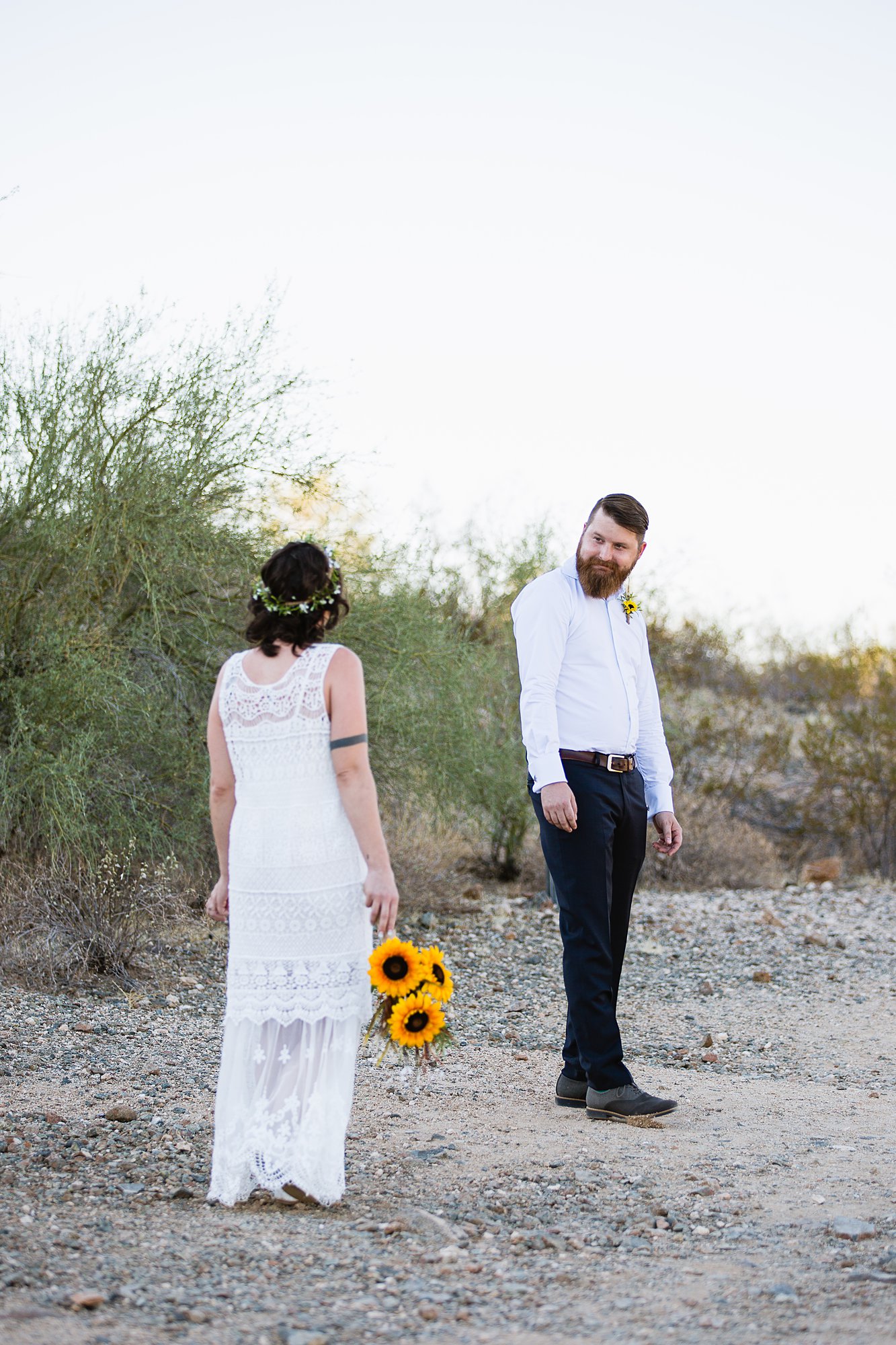 Boho bride and groom during their wedding first look in the Arizona desert by Phoenix wedding photographers PMA Photography.