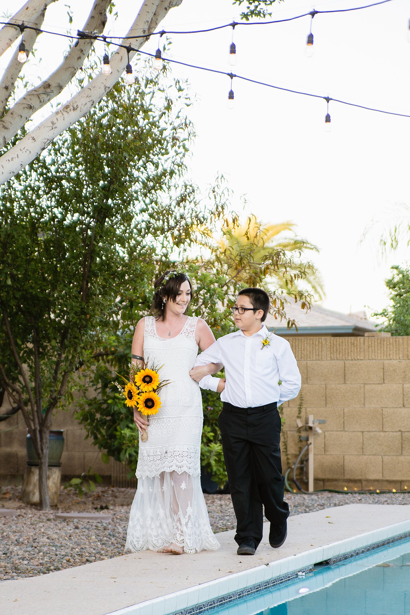Bride being walked down the aisle by her son for her backyard garden wedding by PMA Photography.