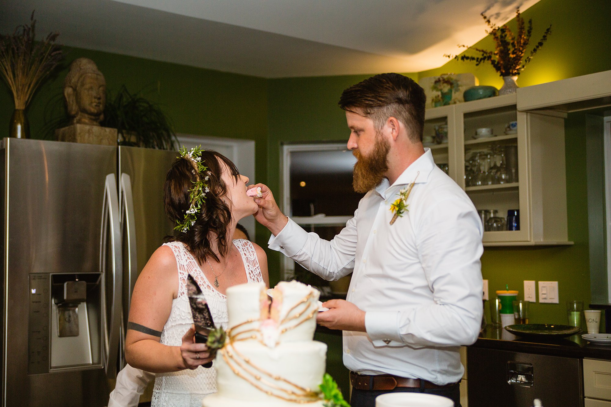 Bride and groom cutting the cake at their intimate backyard wedding by PMA Photography.