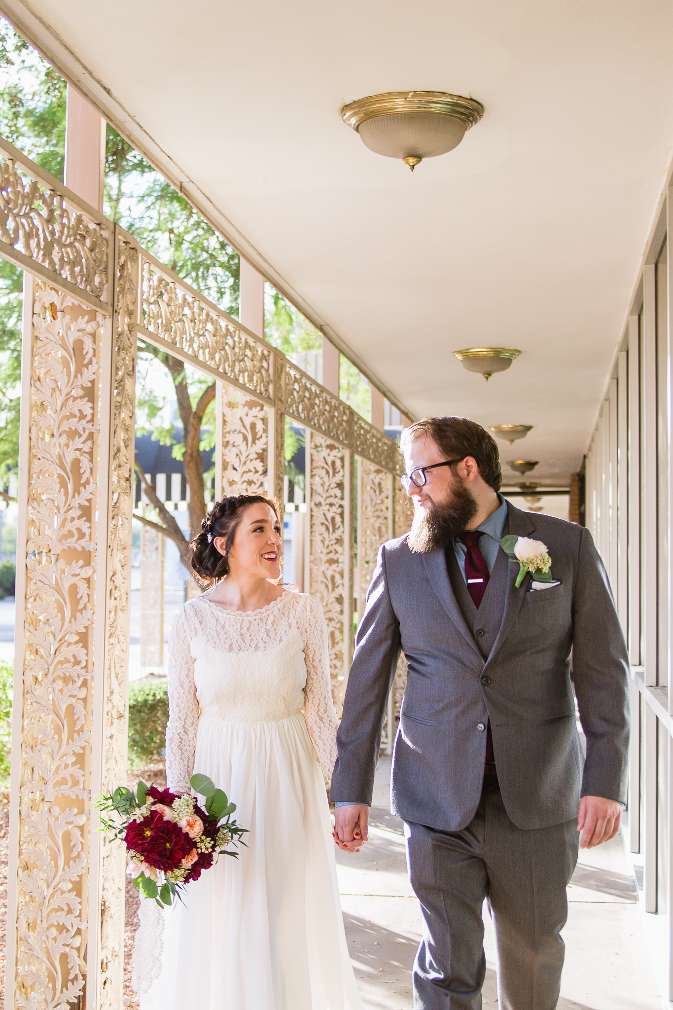 Vintage inspired bride and groom in vintage walkway for their burgundy and cream wedding in downtown Phoenix.