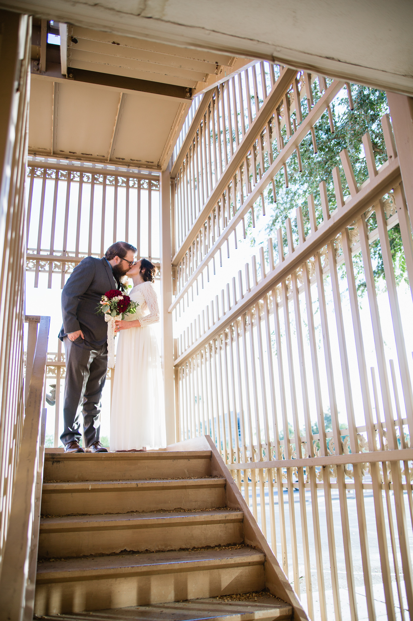 Vintage inspired bride and groom in stairwell for their burgundy and cream wedding in downtown Phoenix.