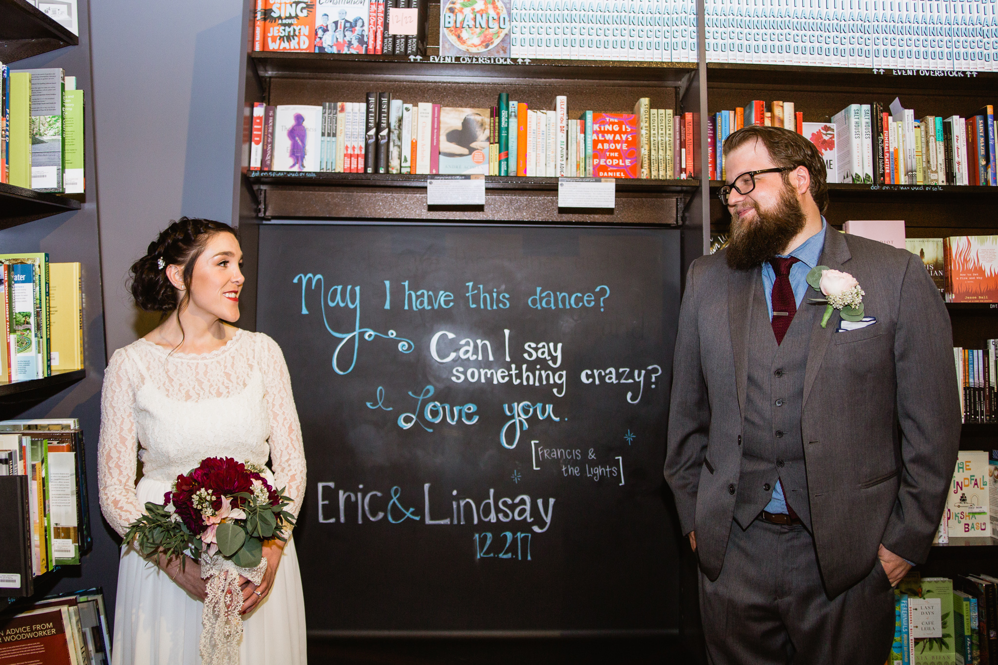 Vintage inspired bride and groom with chalkboard quote from Francis & The Lights in Changing Hands bookstore at their book themed wedding in downtown Phoenix.