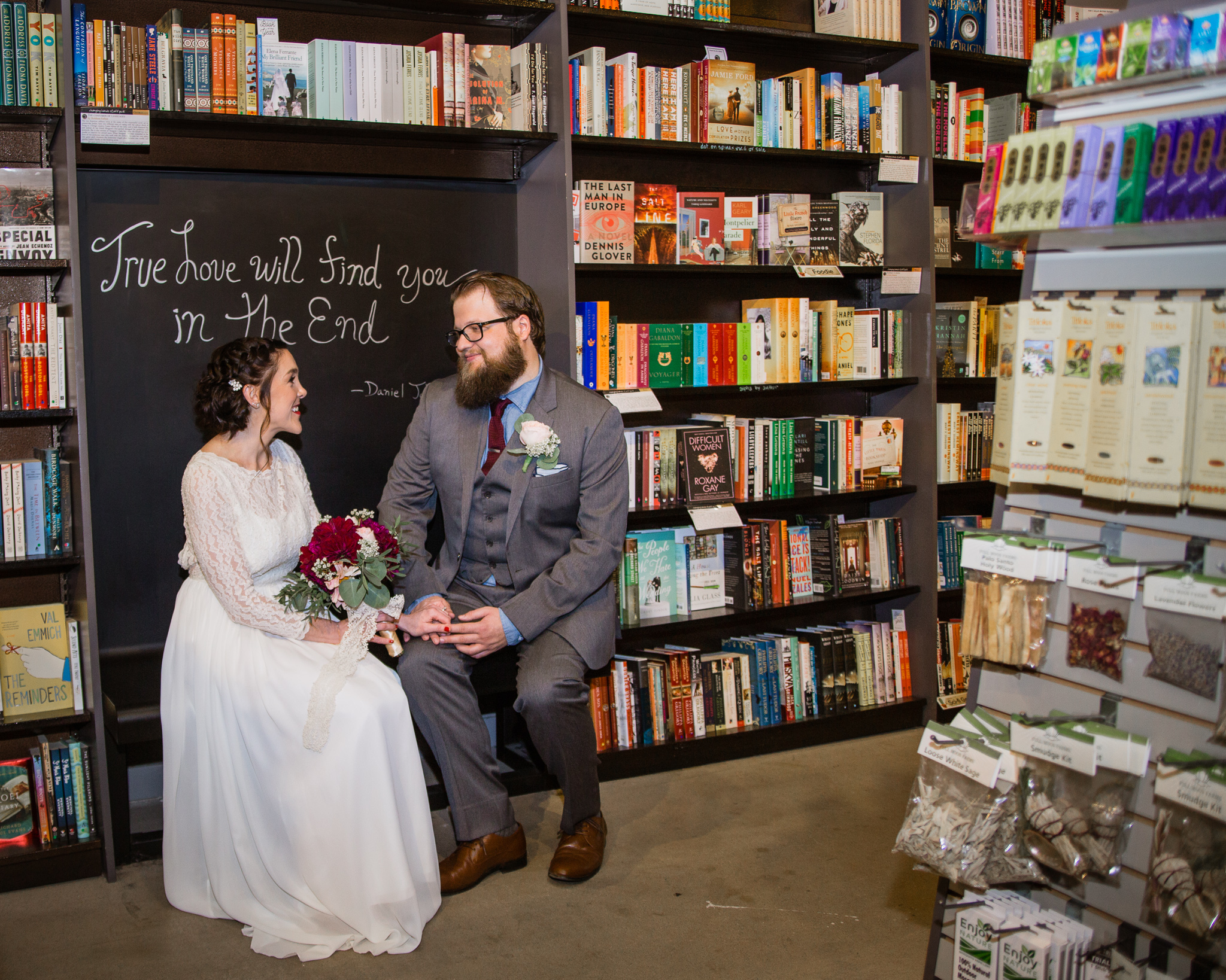 Vintage inspired bride and groom with chalkboard love quote sign in Changing Hands bookstore at their book themed wedding in downtown Phoenix.