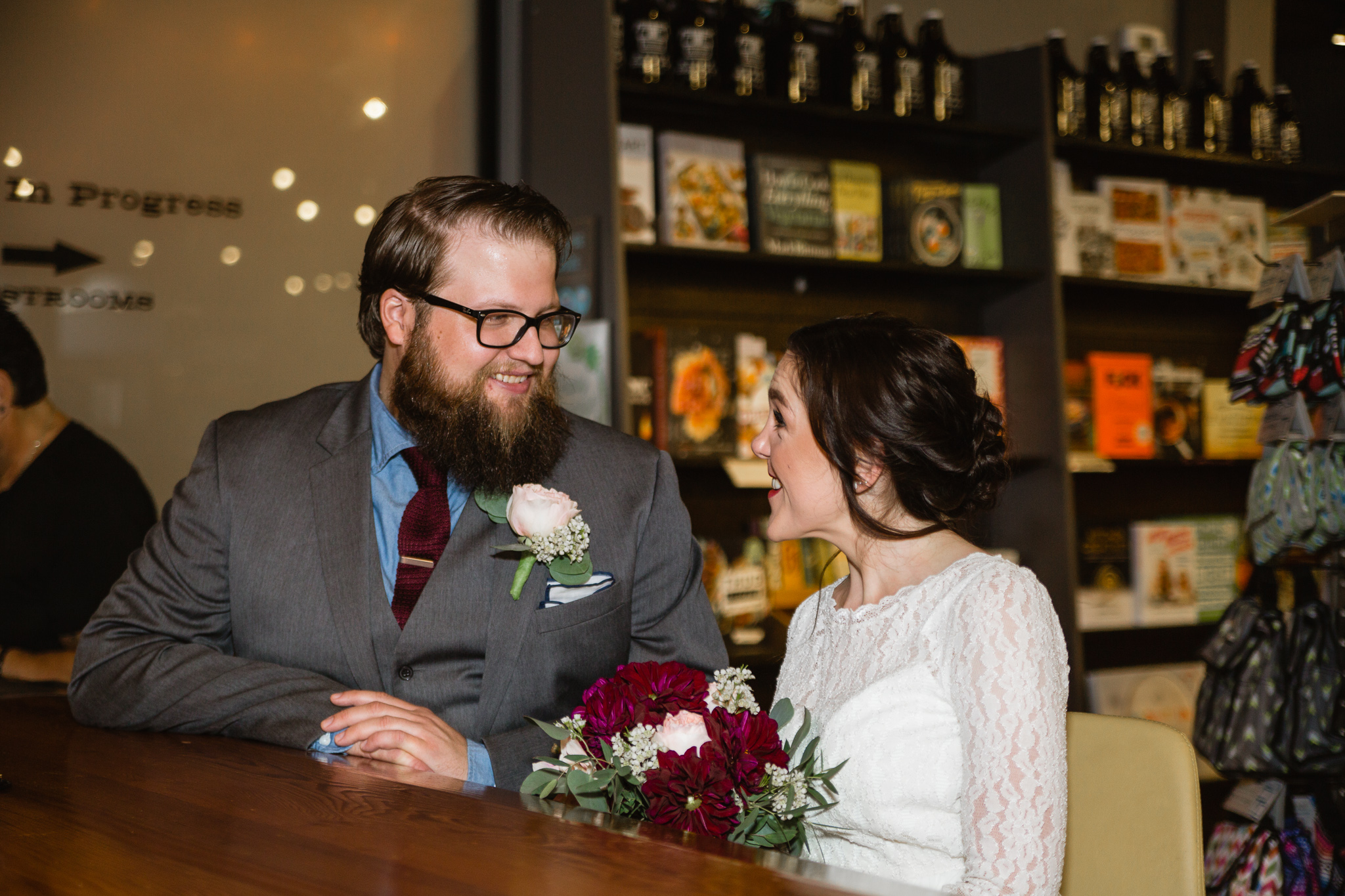 Bride and groom sharing a drink at the First Draft bookstore bar on their wedding day.