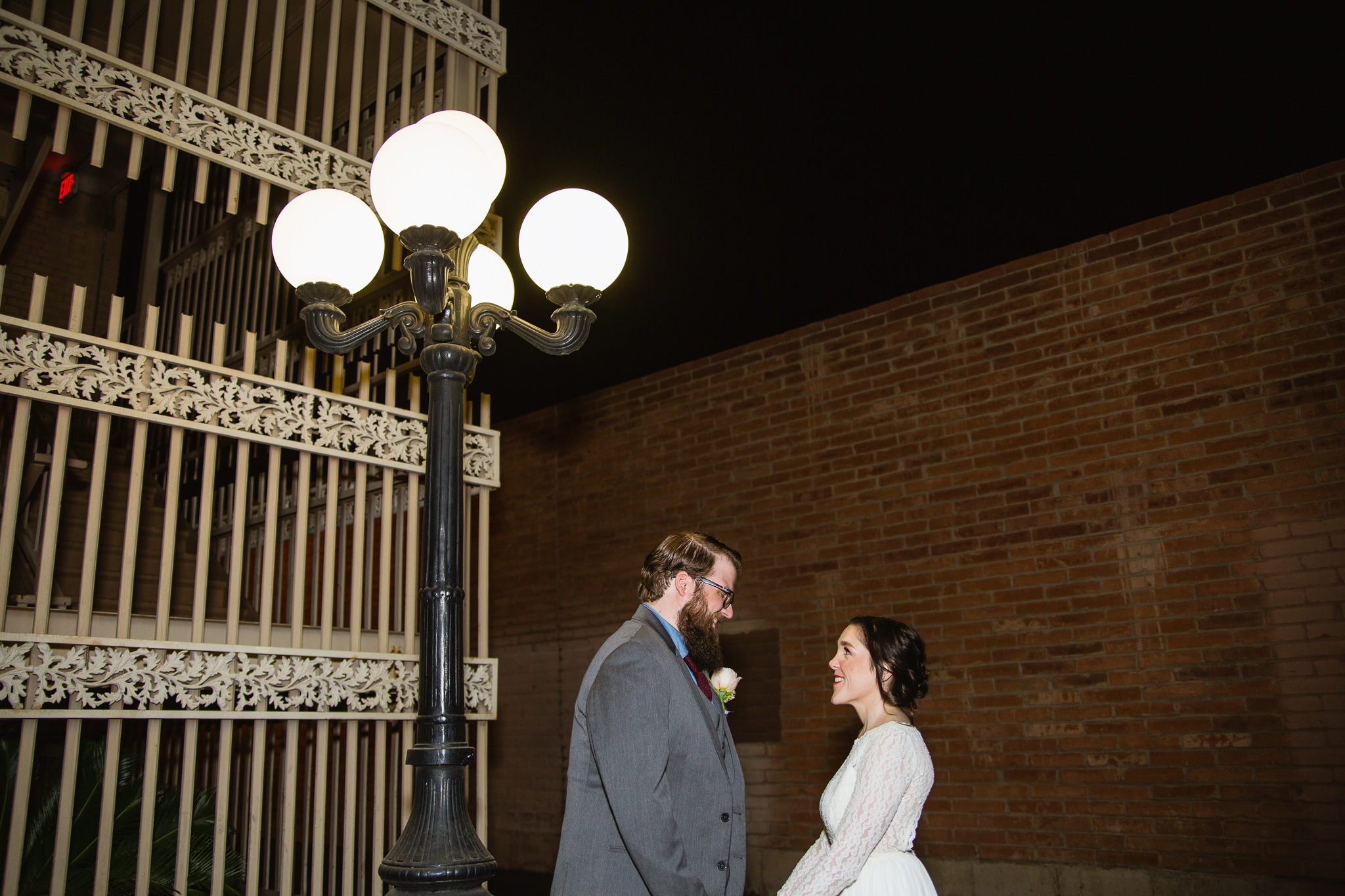 Vintage inspired bride and groom in front of a vintage stairwell and lamp on their wedding day.