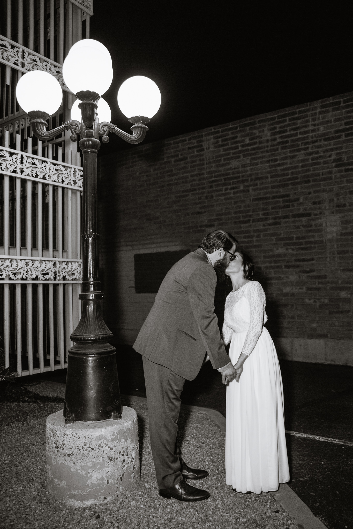 Vintage inspired bride and groom in front of a vintage stairwell and lamp on their wedding day.