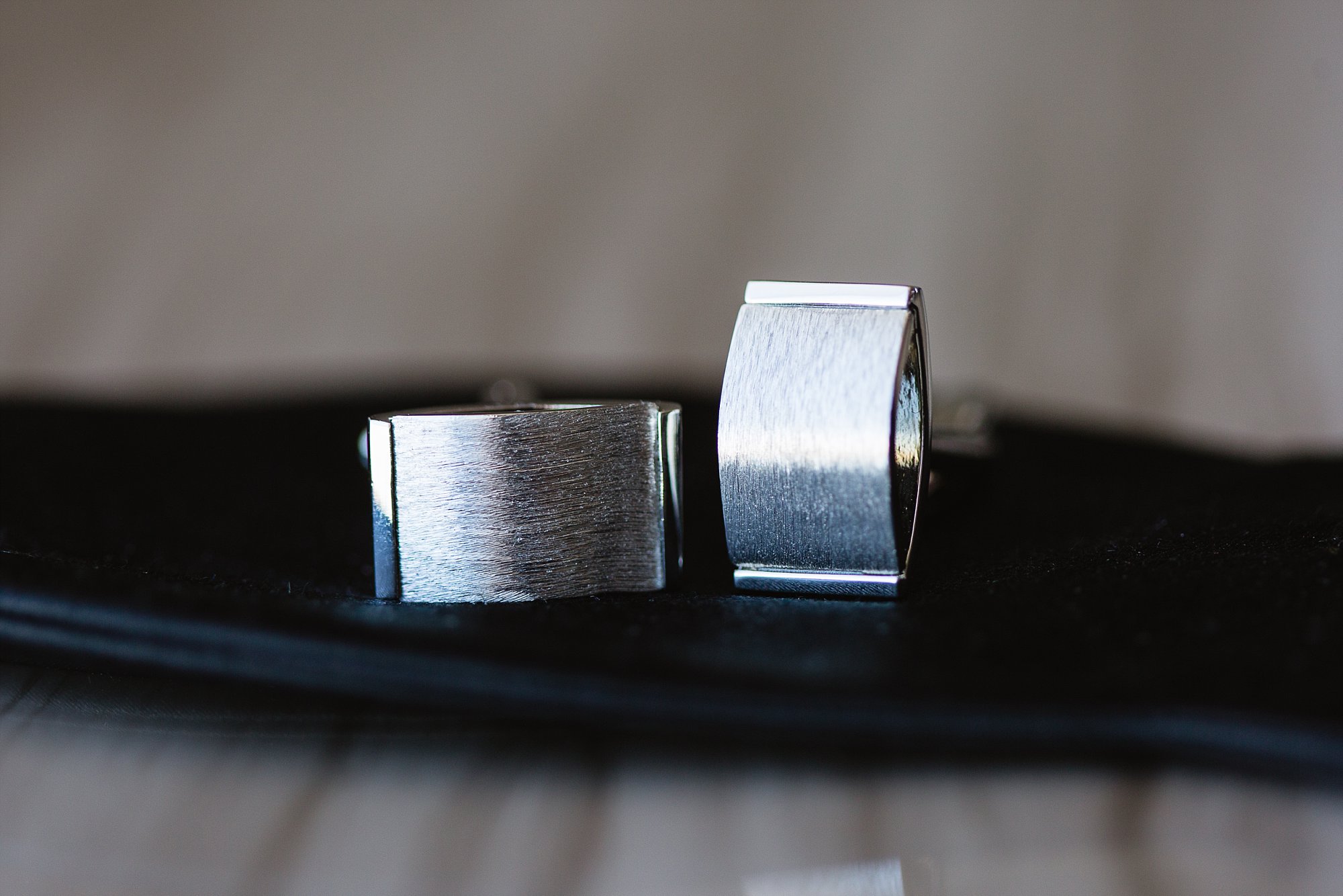Close up image of groom's cuff links on top of his bow tie by Phoenix wedding photographers PMA Photography.