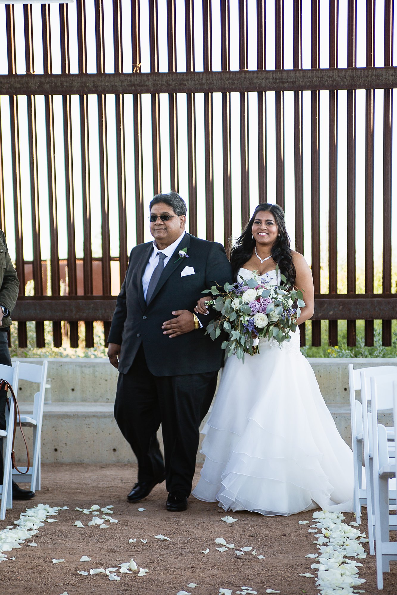 Bride walking down the aisle with her father during wedding ceremony at the Rio Salado Audubon by Phoenix wedding photographers PMA Photography.