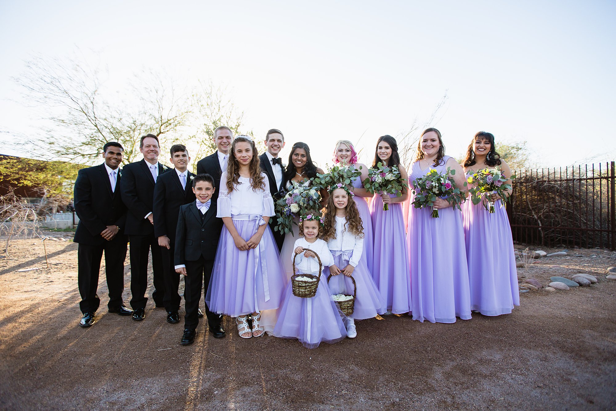Lavender bridal party with bride and groom, groomsmen, bridesmaids, ring bearer, and flower girls by wedding photographer PMA Photography.