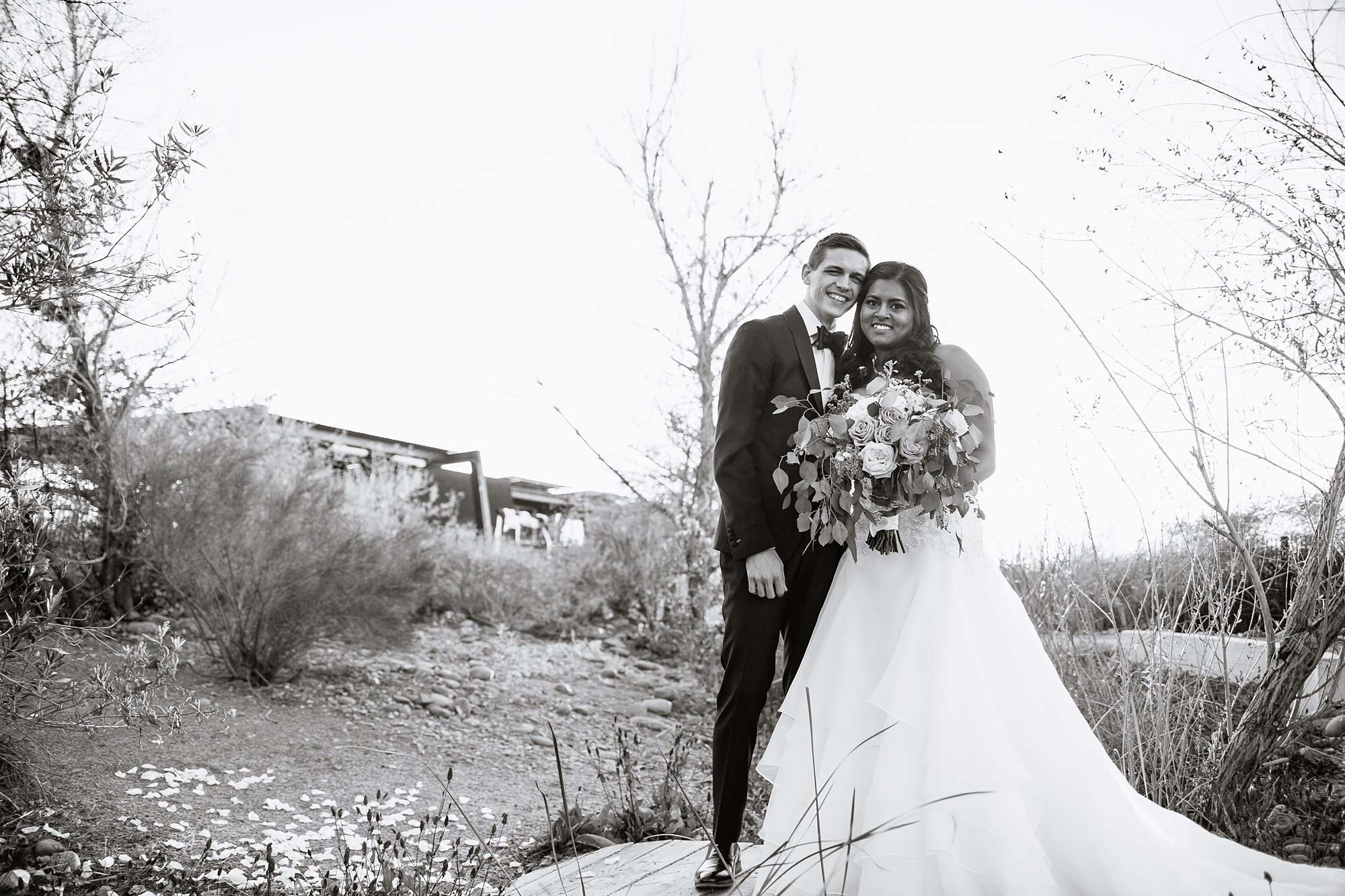 Black and White image of bride and groom on small bridge at the Rio Salado Audubon Center by Phoenix Wedding photographer PMA Photography.