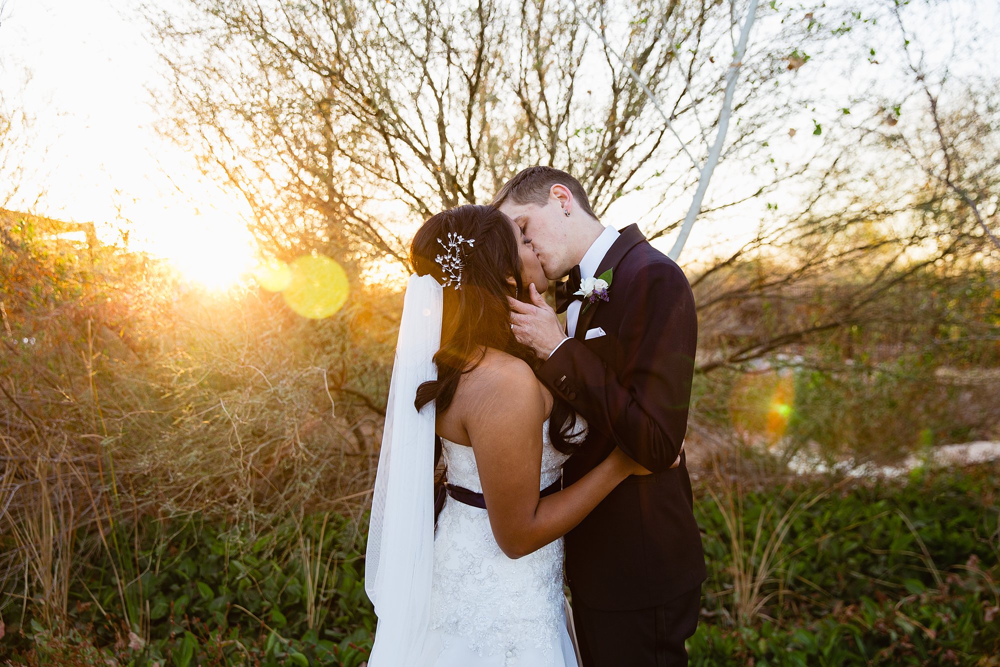 Sun flare in a photograph of a bride and groom kissing on their wedding day.