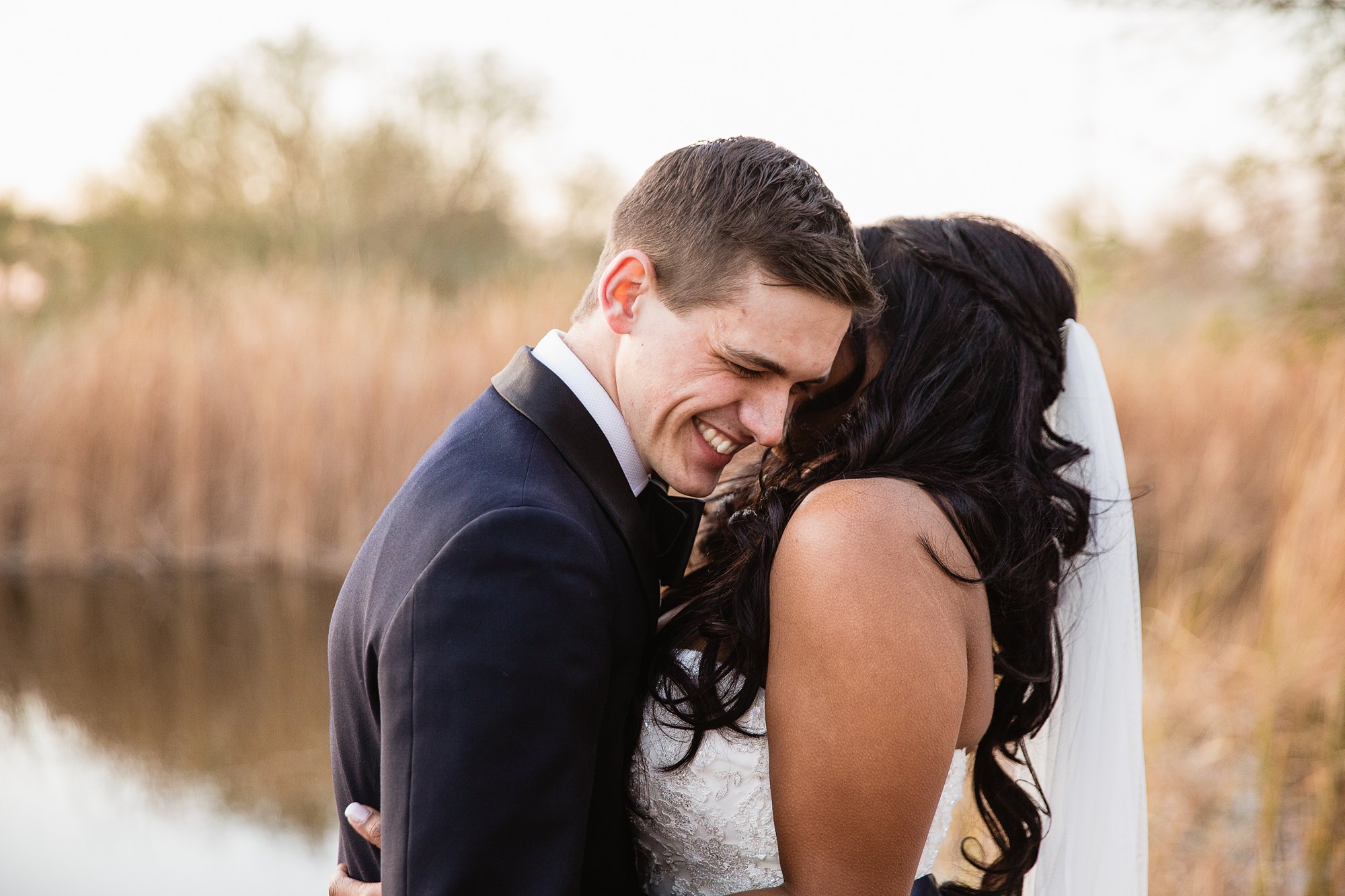Groom reacting to the bride telling him one reason she loves him on their wedding day at the Rio Salado Audubon center by Phoenix wedding photographer PMA Photography.