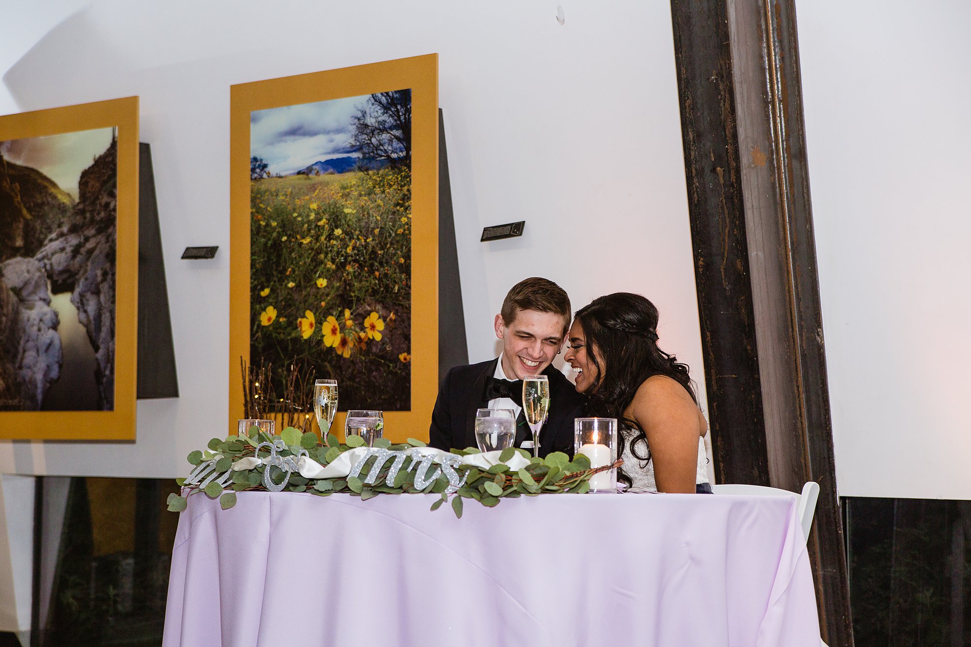 Bride and groom sitting at their head table at the Rio Salado Audubon center by Phoenix wedding photographer PMA Photography.