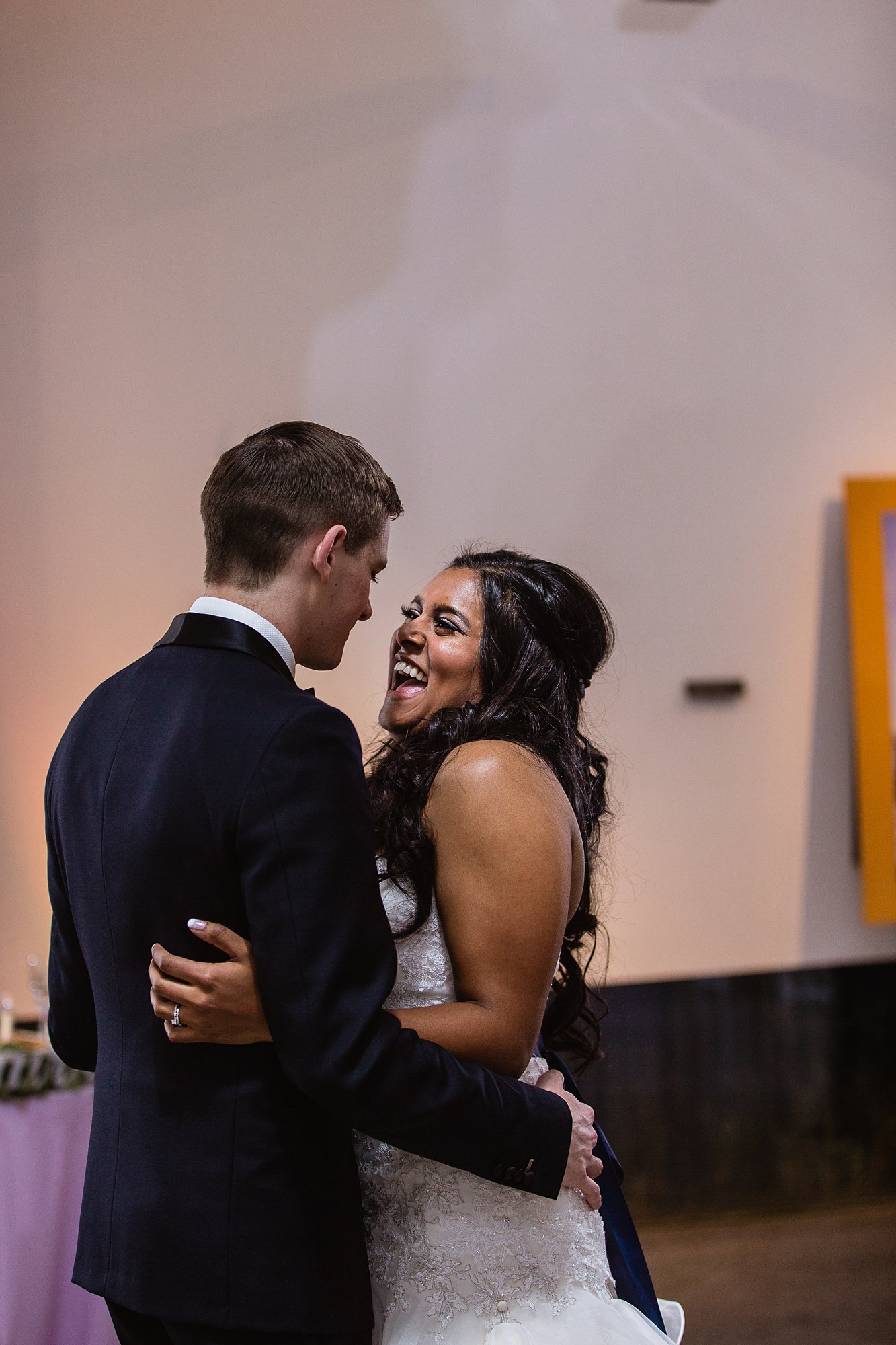 Bride laughing at groom during their first dance at their reception at the Rio Salado Audubon center by Phoenix wedding photographer PMA Photography.
