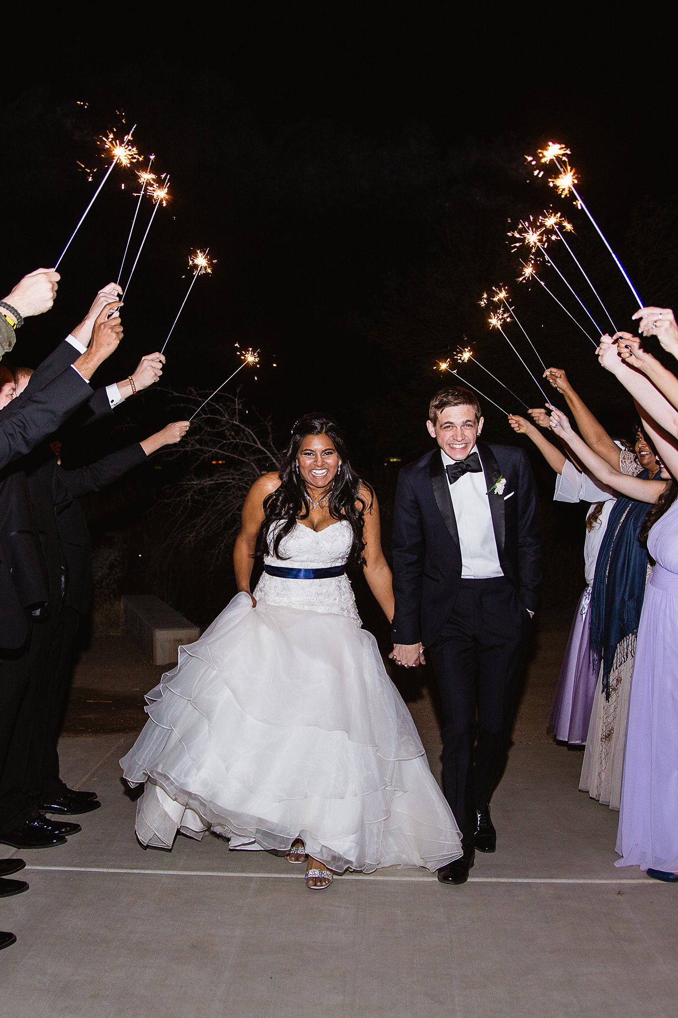 Bride and groom running through their sparkler exit by wedding photographer PMA Photography.