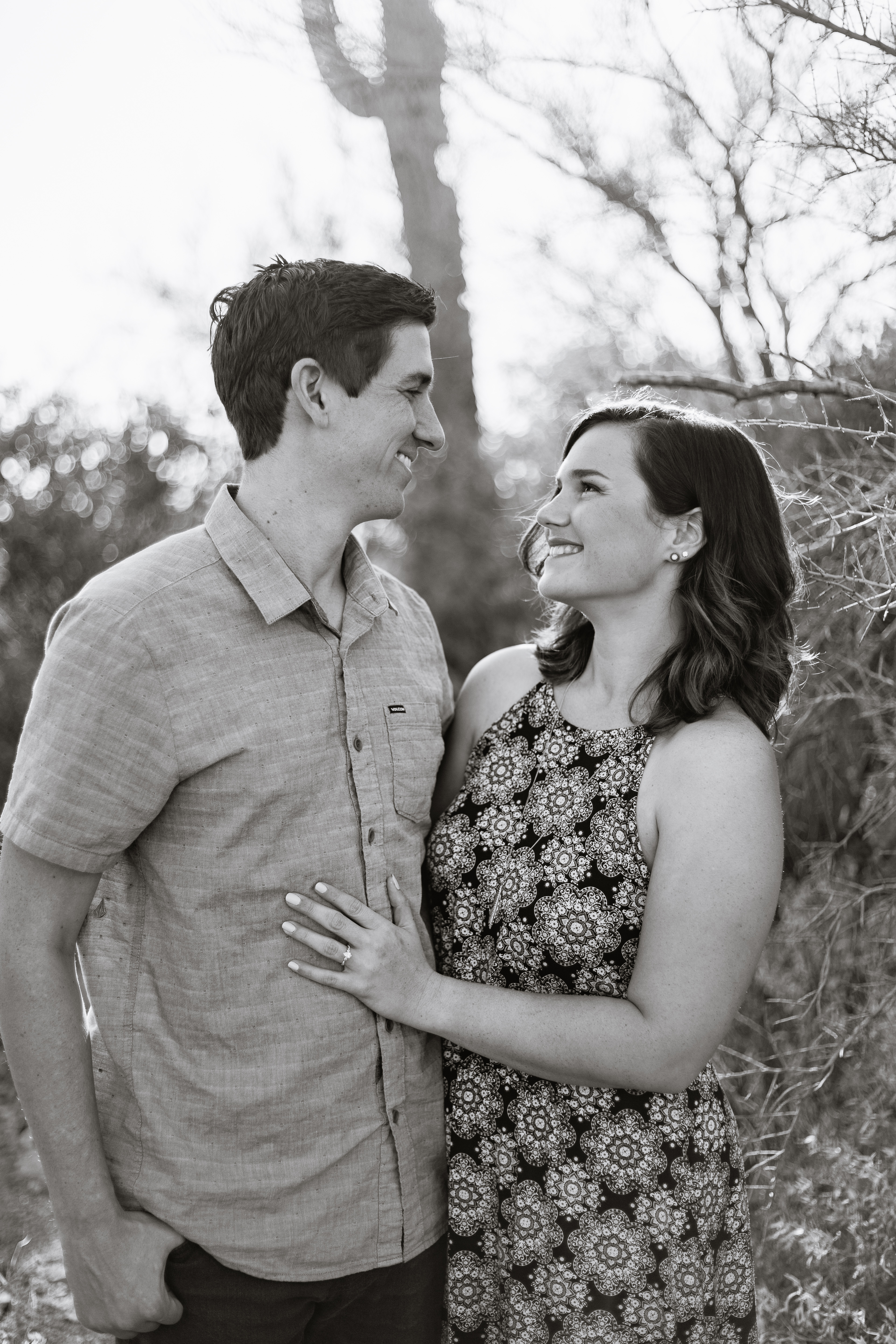 Black and white image of couple looking at each other at desert engagement session at Lost Dutchman State Park by wedding photographer PMA Photography.