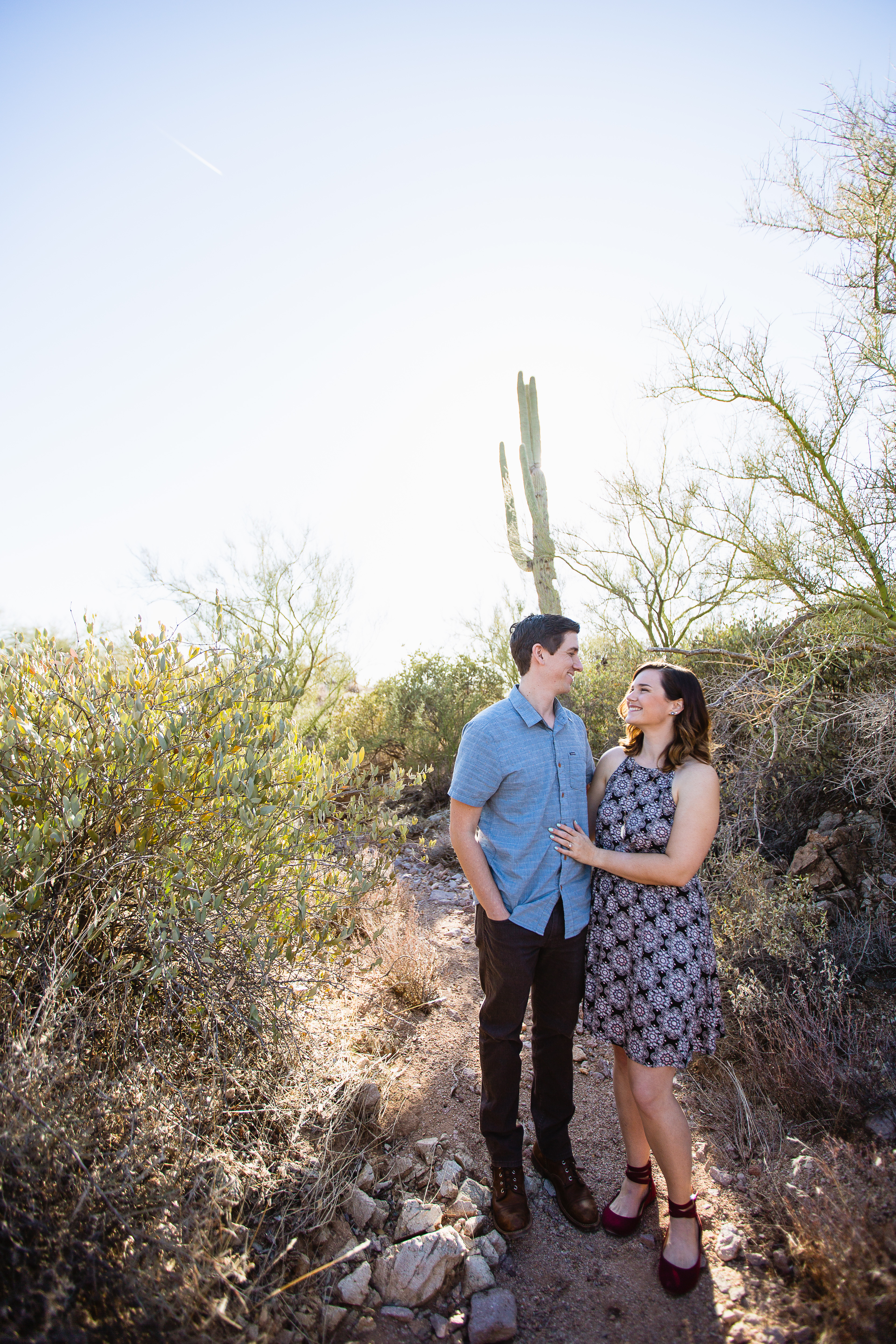 Couple looking at each other at desert engagement session at Lost Dutchman State Park by wedding photographer PMA Photography.
