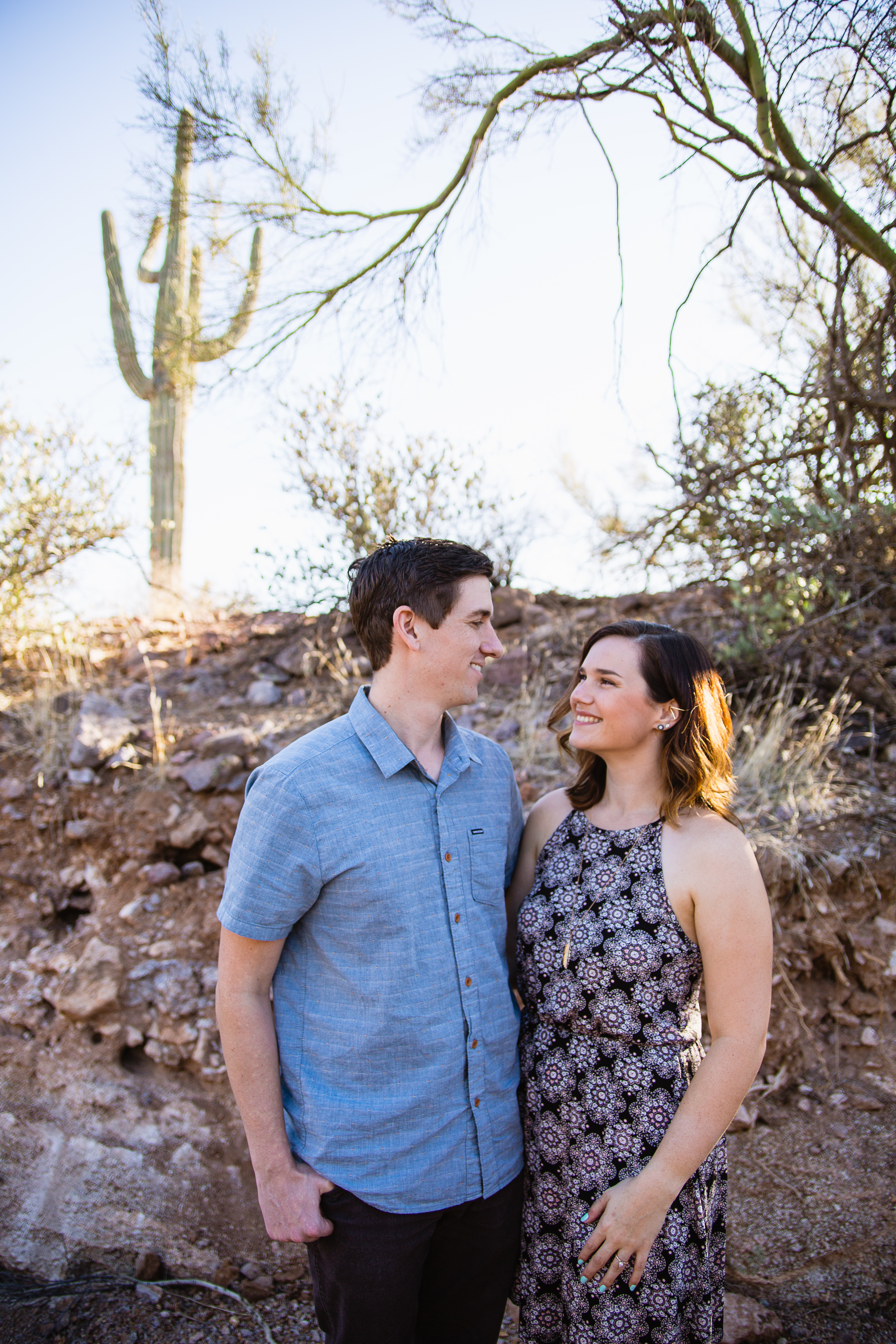 Couple looking at each other during desert engagement session at Lost Dutchman State Park by engagement photographer PMA Photography.