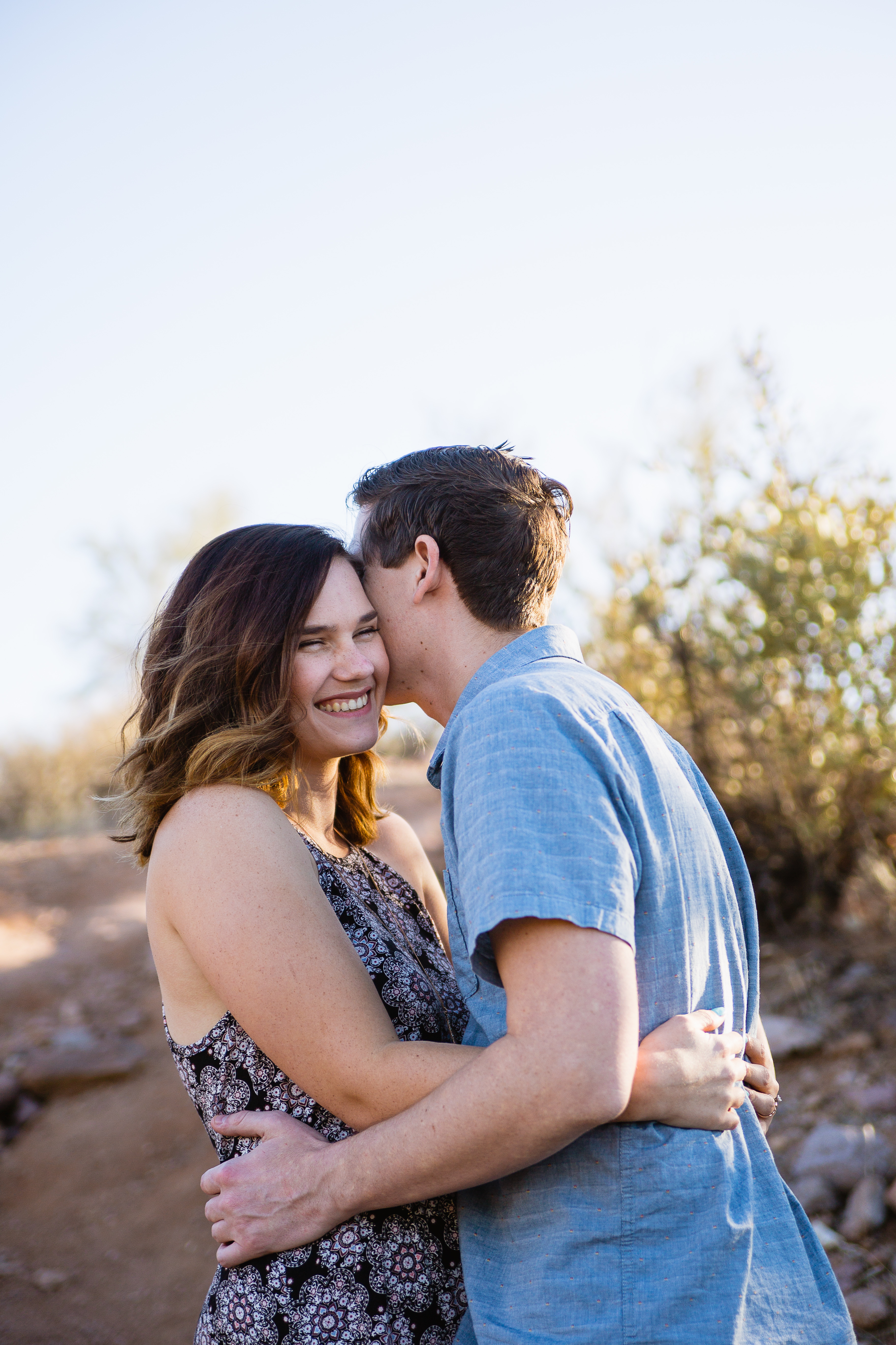 Couple sharing one reason they love each other at desert engagement session at Lost Dutchman State Park by Phoenix engagement photographers PMA Photography.